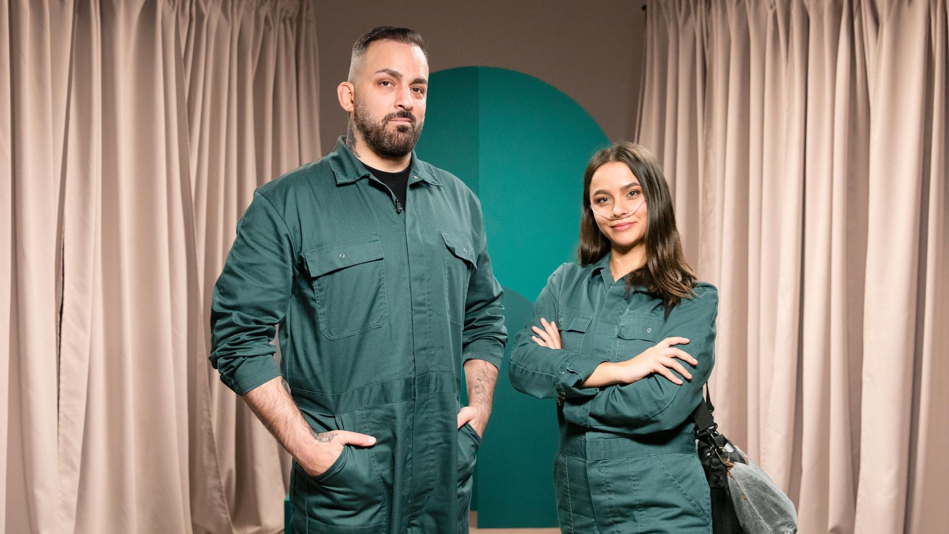 Die Gäste der Sendung stehen in grünen Overalls vor der Kamera.