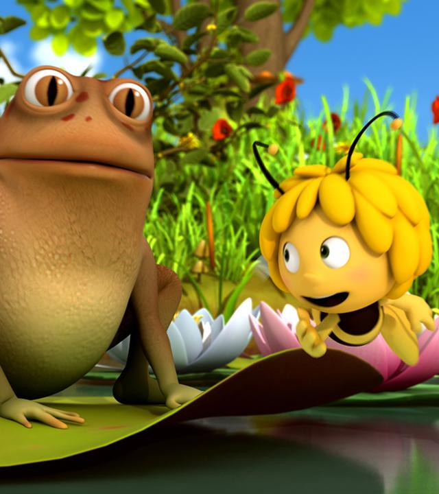 Maja und Willi fliehen vor dem großen Frosch, der auf einer Seerose sitzt.