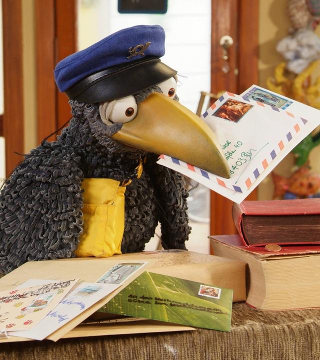 Rabe Rudi als Postbote hat Briefe im Schnabel