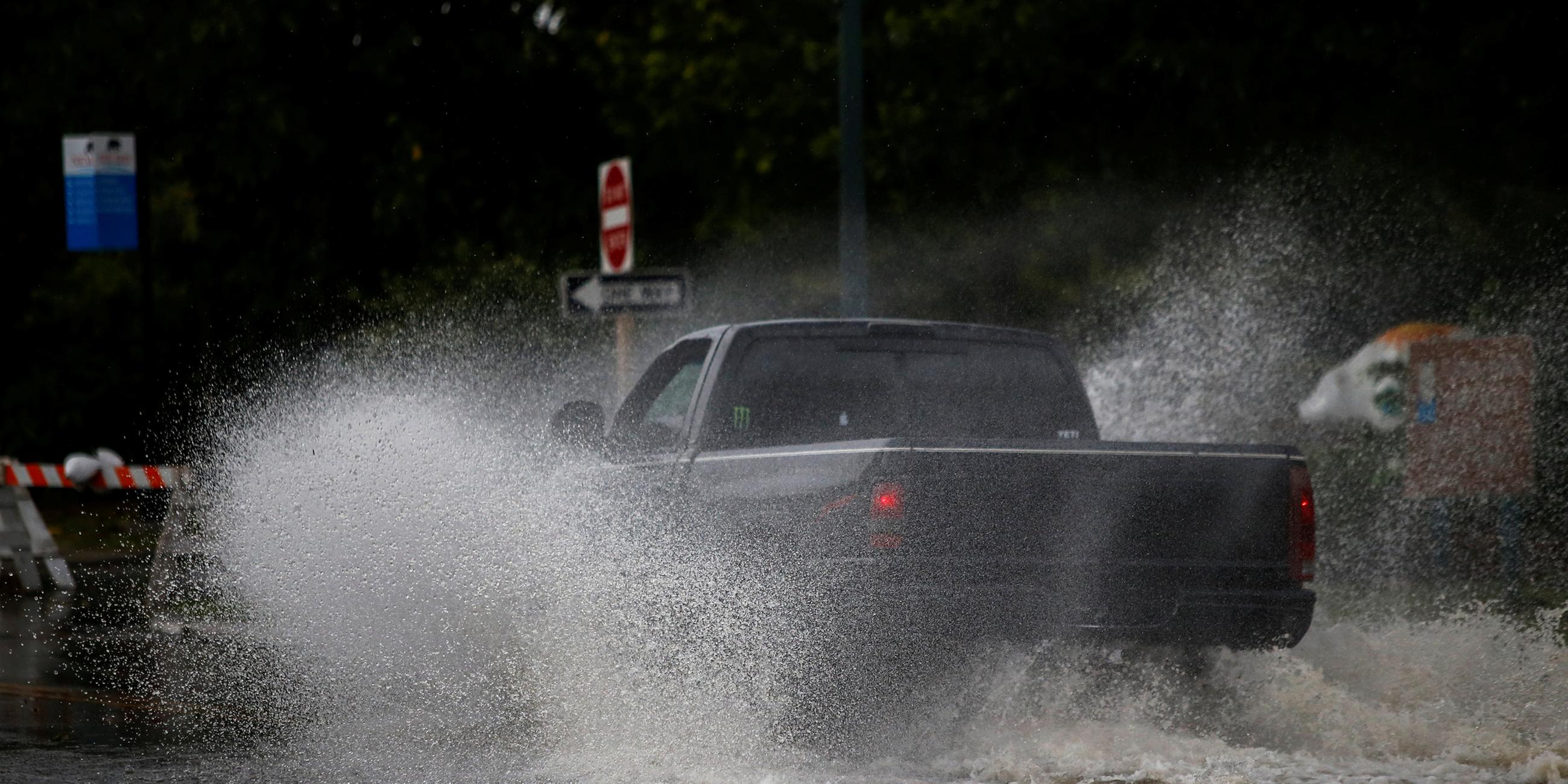 Ein Pickup fährt durch die von den ersten Ausläufern von Hurrikan Florence überfluteten Straßen.