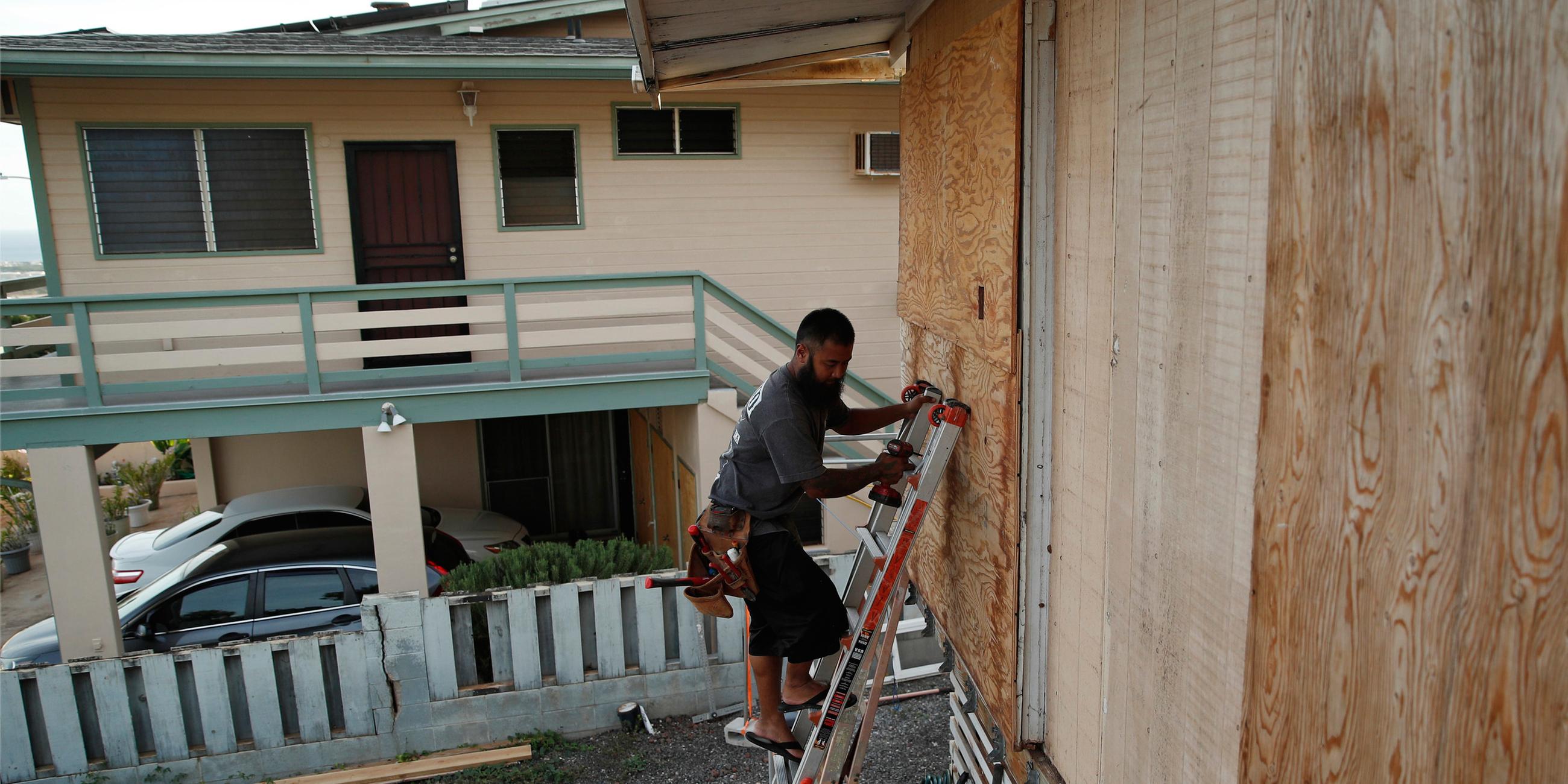 Kaipo Popa sichert Sperrholz, um Fenster auf einem Haus in der Vorbereitung für Hurrikan Lane am 23.08.2018 in Kapolei (USA)