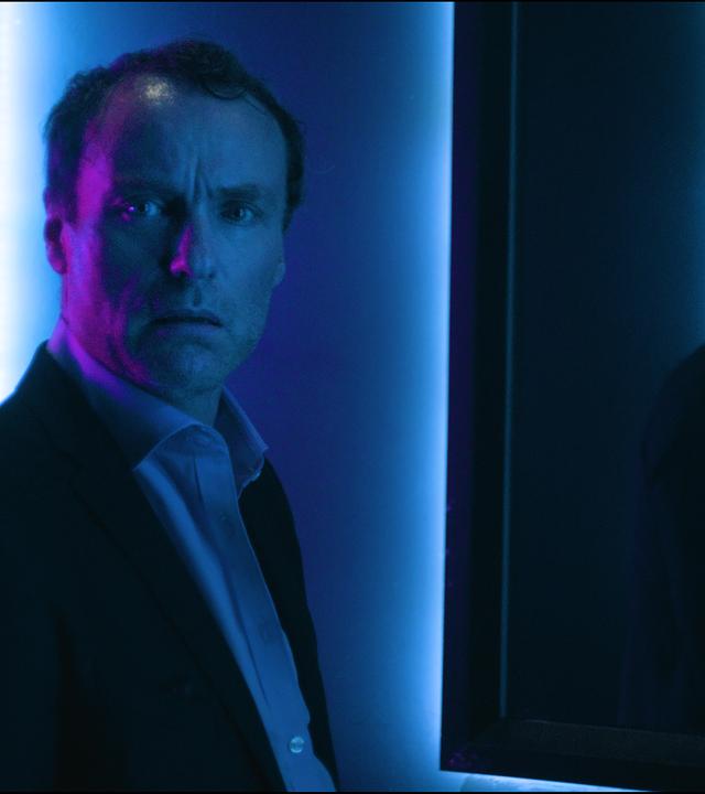 "I AM THE GREATEST - Agent of Change": Karsten Drechsler (Mark Waschke) sieht sich selbst im Spiegel und schaut kritisch.