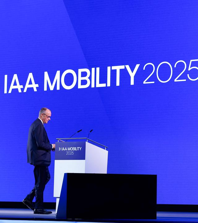 Bayern, München: Bundeskanzler Merz steht auf der Bühne bei der Eröffnung der Automesser IAA.