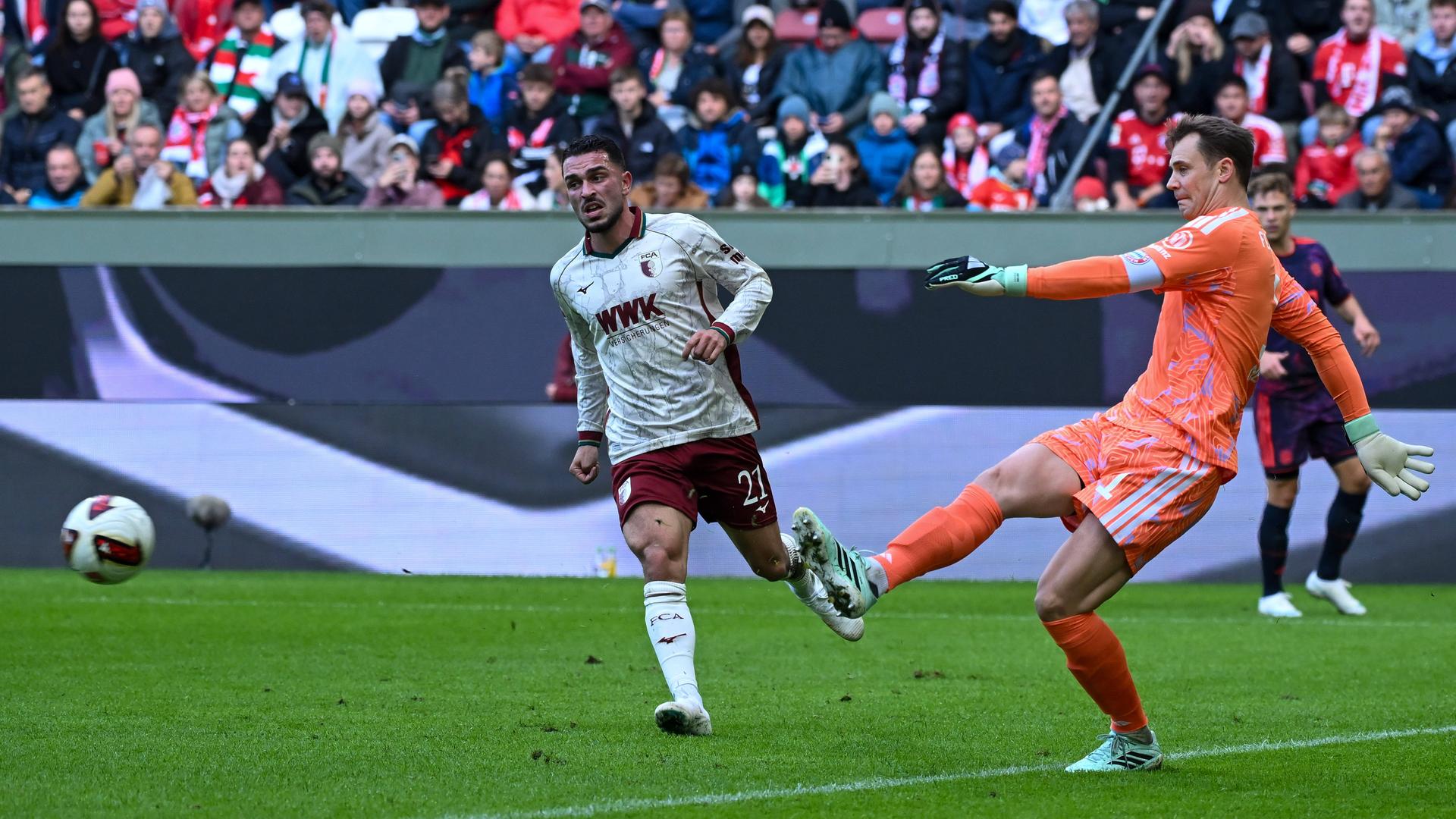 Bayerns Keeper Manuel Neuer klärt den Ball rechtzeitig vor dem Augsburger Arijon Ibrahimović
