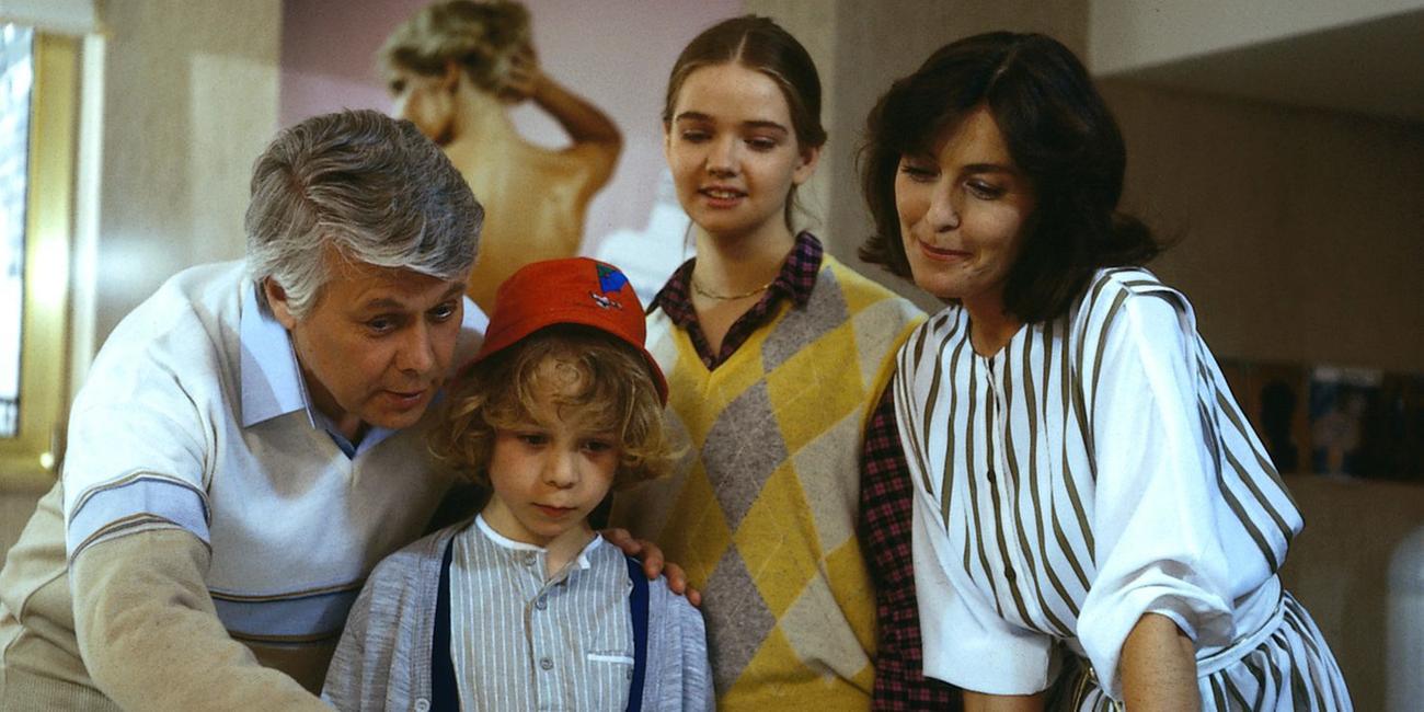 Angelika und Werner stehen mit den Kindern Tanja und Markus zusammen. Sie schauen lächelnd in dieselbe Richtung, während Werner mit seinem Finger auf etwas in derselben Richtung zeigt.