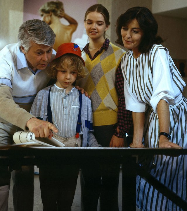 Angelika und Werner stehen mit den Kindern Tanja und Markus zusammen. Sie schauen lächelnd in dieselbe Richtung, während Werner mit seinem Finger auf etwas in derselben Richtung zeigt.