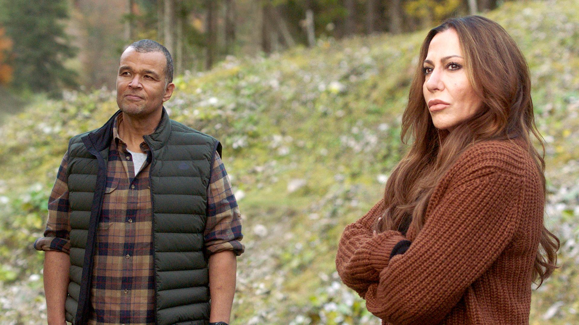 Katja Baumann (Simone Thomalla) und Louis Keita (Nikolaus Okonkwo) stehen mit ernstem Gesichtsausdruck in den Bergen.