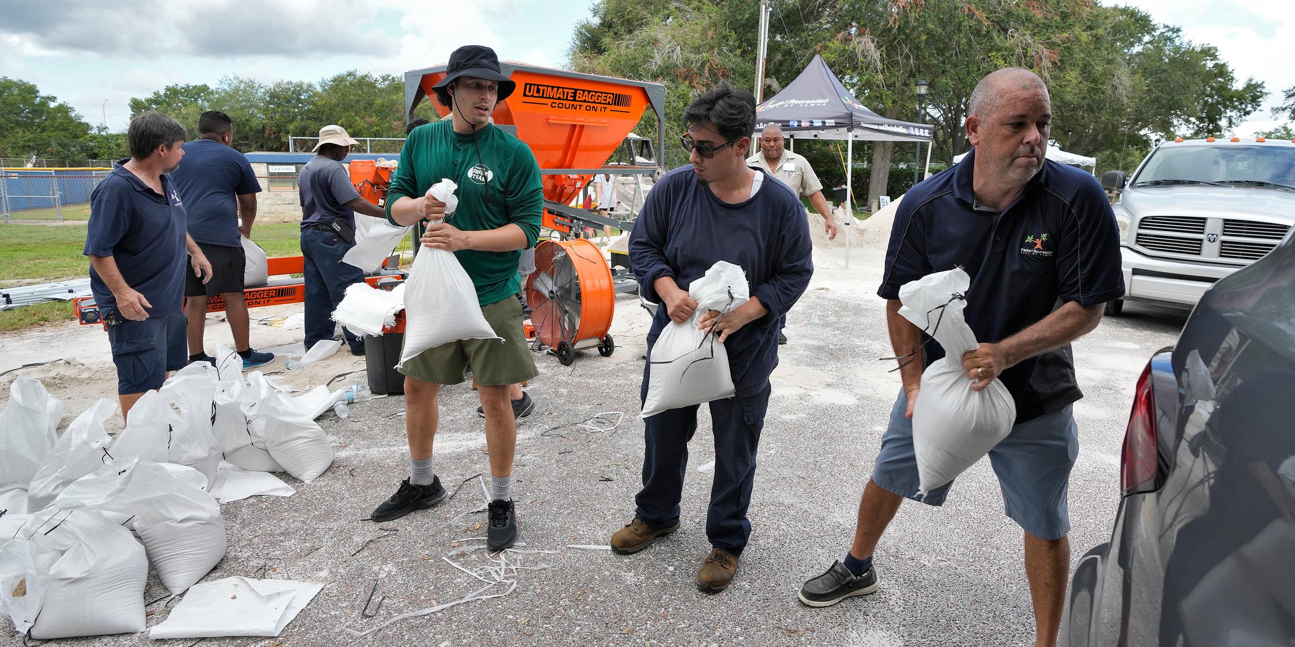 Mitarbeiter der Park- und Freizeitbehörde von Tampa helfen Anwohnern beim Verladen von Sandsäcken, aufgenommen am 28.08.2023 in Tampa. Florida, USA