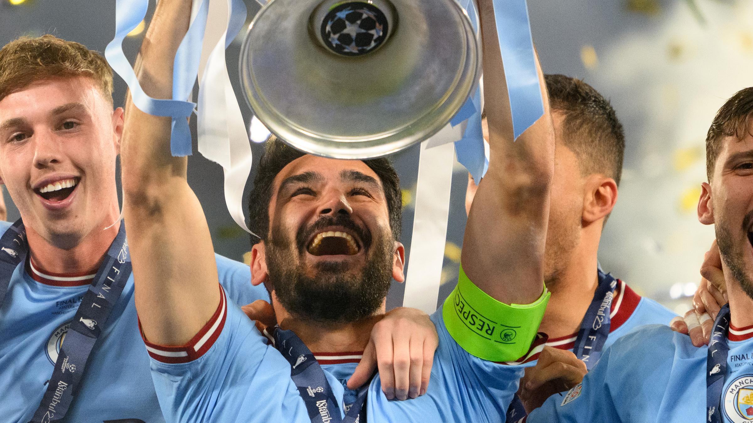 Ilkay Gündogan (M) jubelt bei der Siegerehrung mit der Trophäe.