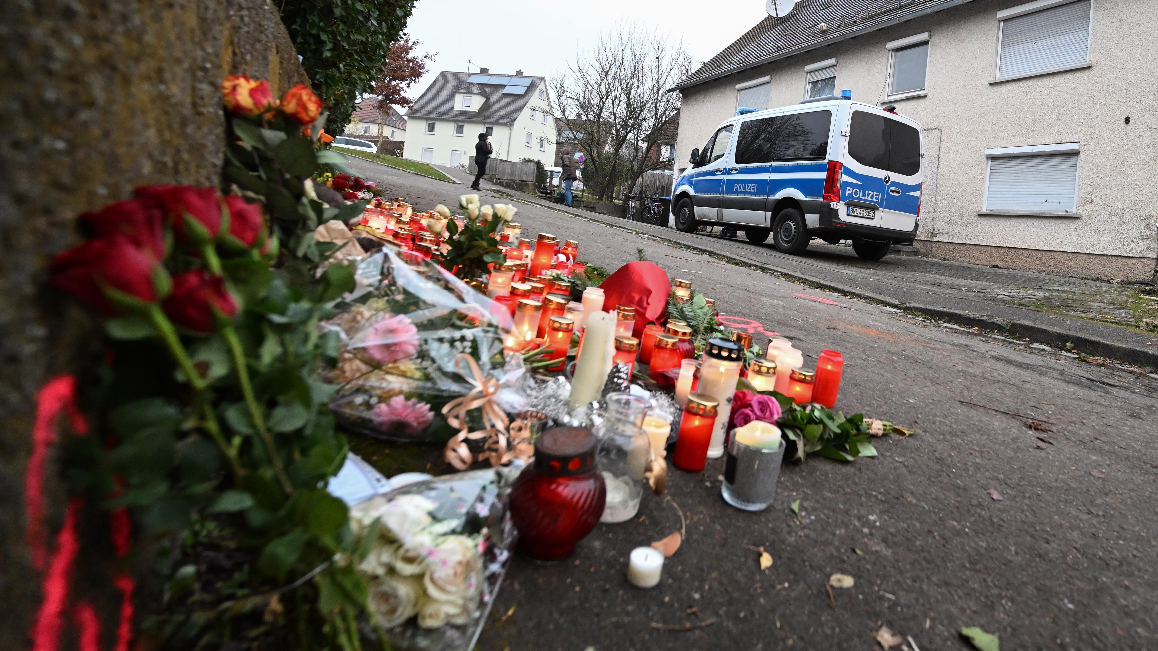 Kerzen und Blumen stehen an einem Tatort in Illerkirchberg, aufgenommen am 06.12.2022