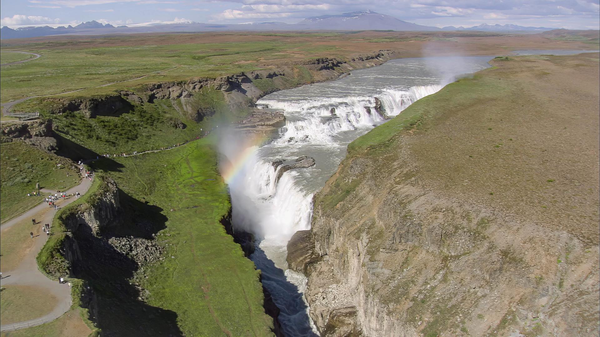 Luftaufnahme eines Wasserfalls, dessen Wasser in eine tiefe Schlucht fließt.