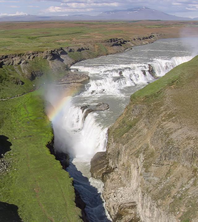 Luftaufnahme eines Wasserfalls, dessen Wasser in eine tiefe Schlucht fließt.