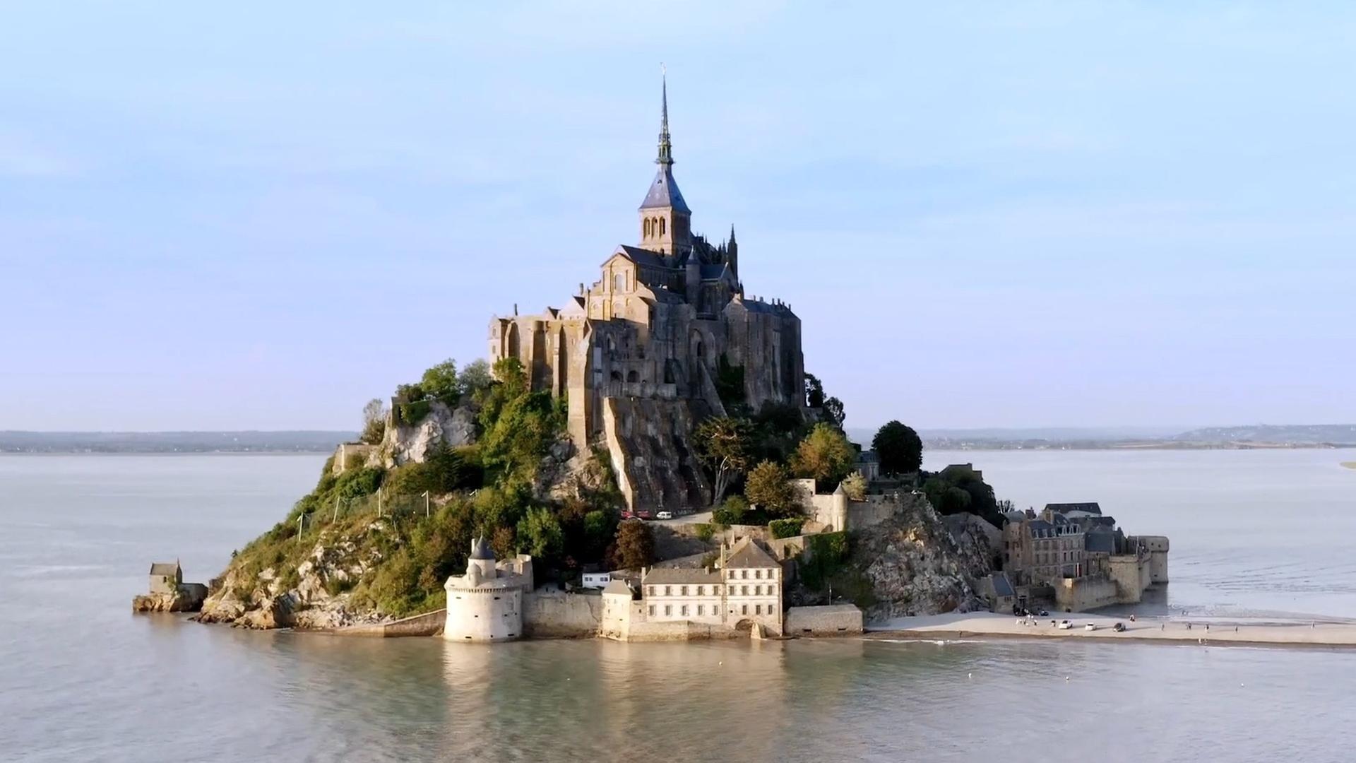 Mont-Saint-Michel ist eine beeindruckende, auf einer Felsinsel gelegene Abtei in der Normandie. Vom Meer umgeben und seien Strasse führt dorthin.