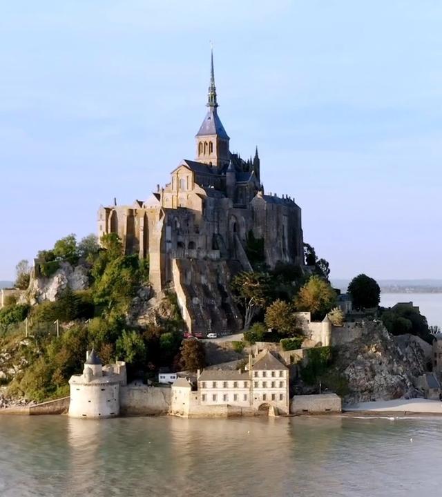 Mont-Saint-Michel ist eine beeindruckende, auf einer Felsinsel gelegene Abtei in der Normandie. Vom Meer umgeben und seien Strasse führt dorthin.