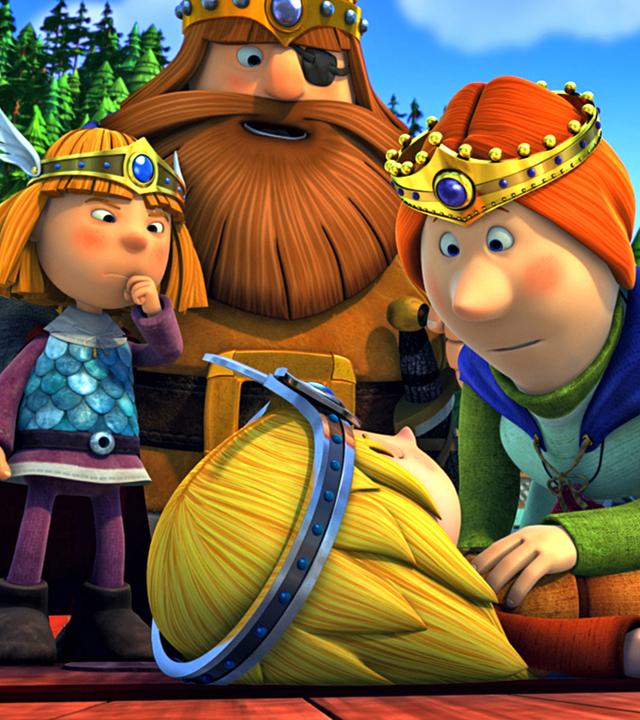 Die Wikinger spielen Theater. Im Vordergrund liegt Ylvi verkleidet als Gott der Freude auf dem Boden, Ylva beugt sich als Frigg über sie. Dahinter stehen die Wikinger. Wickie spielt Thor, den Gott des Donners. Rechts neben ihm steht Halvar als Odin. Gorm und Ulm sind ebenfalls verkleidet.