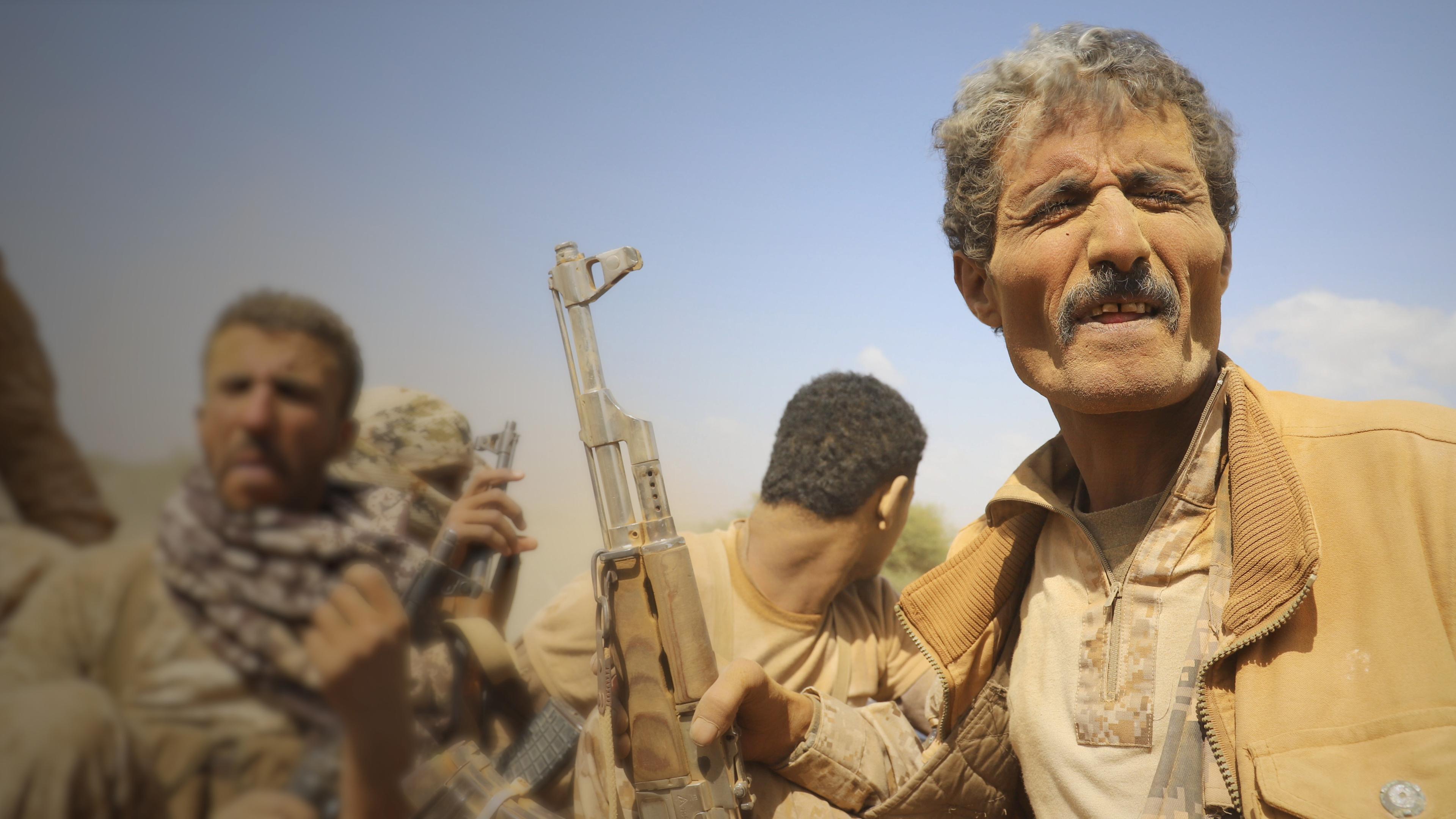 Mitglieder der jemenitischen Regierungstruppen 2022: drei bewaffnete Männer, einer schaut nach hinten.
