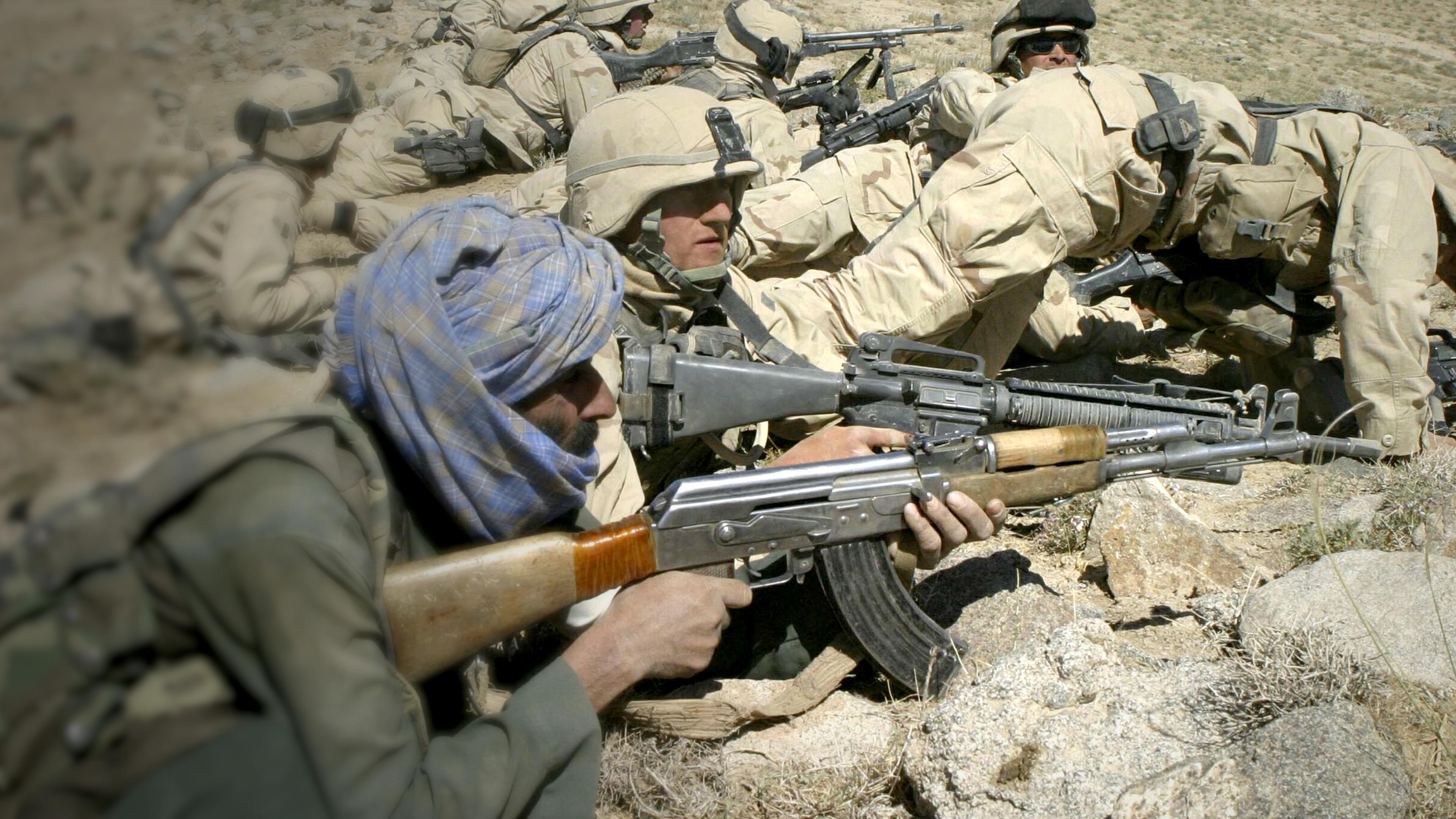 Mehrere US-Marines liegen mit Waffen am Boden, in Afghanistan 2004.