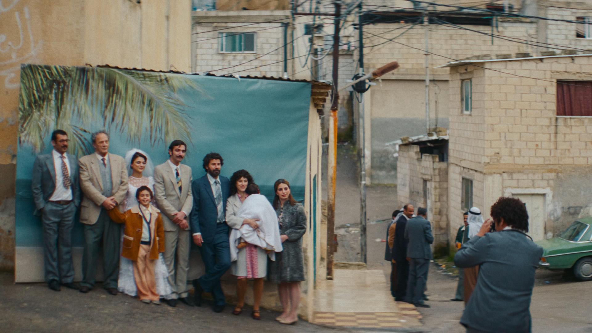 Gruppe Menschen steht vor einem Bild mit Palmen