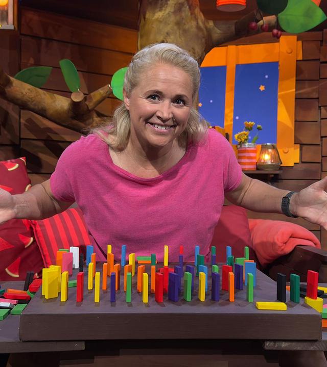 Singa baut eine Strecke aus Dominosteinen