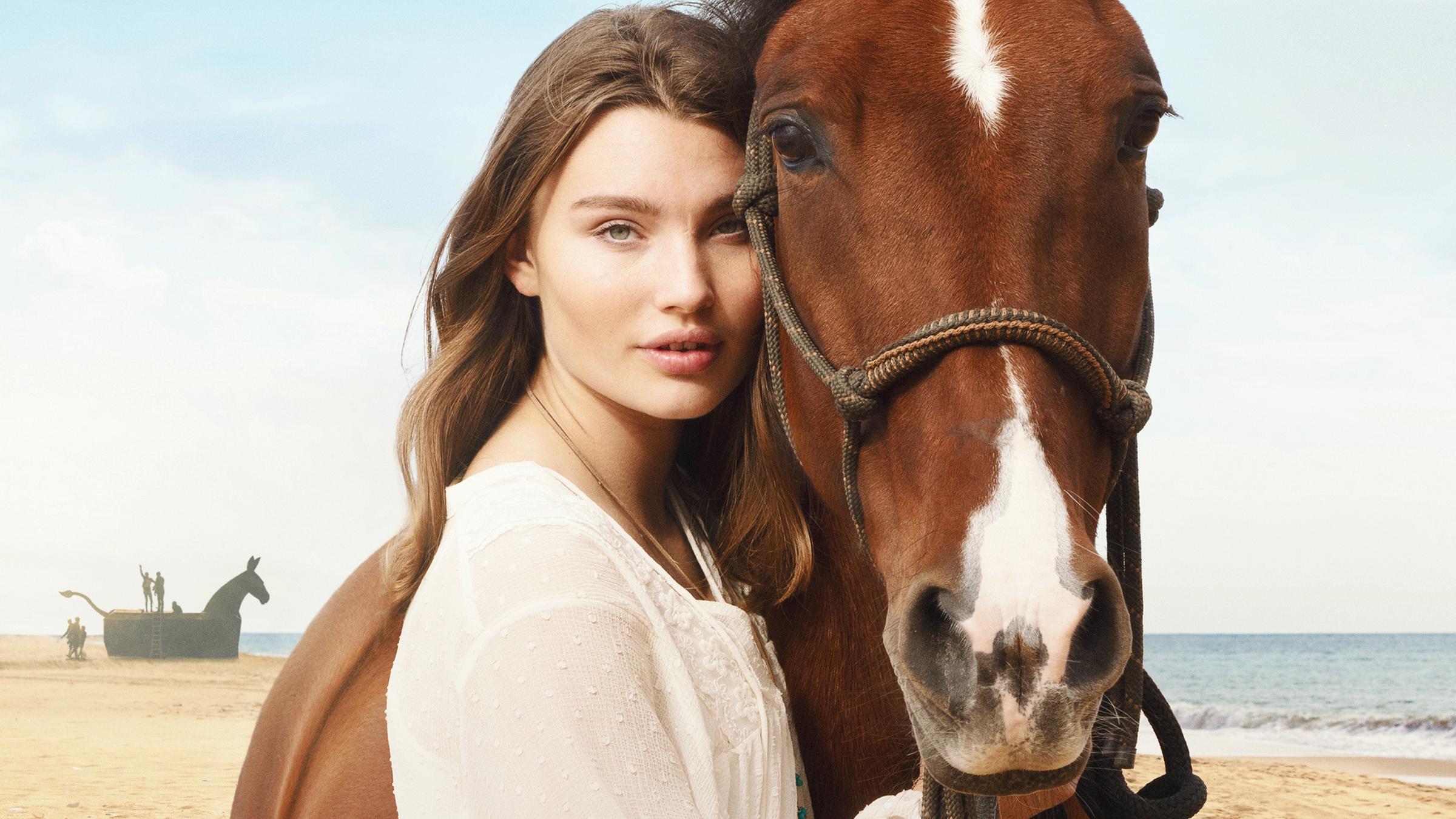 Lou (Leia Holtwick) lehnt ihren Kopf an den eines Pferdes.