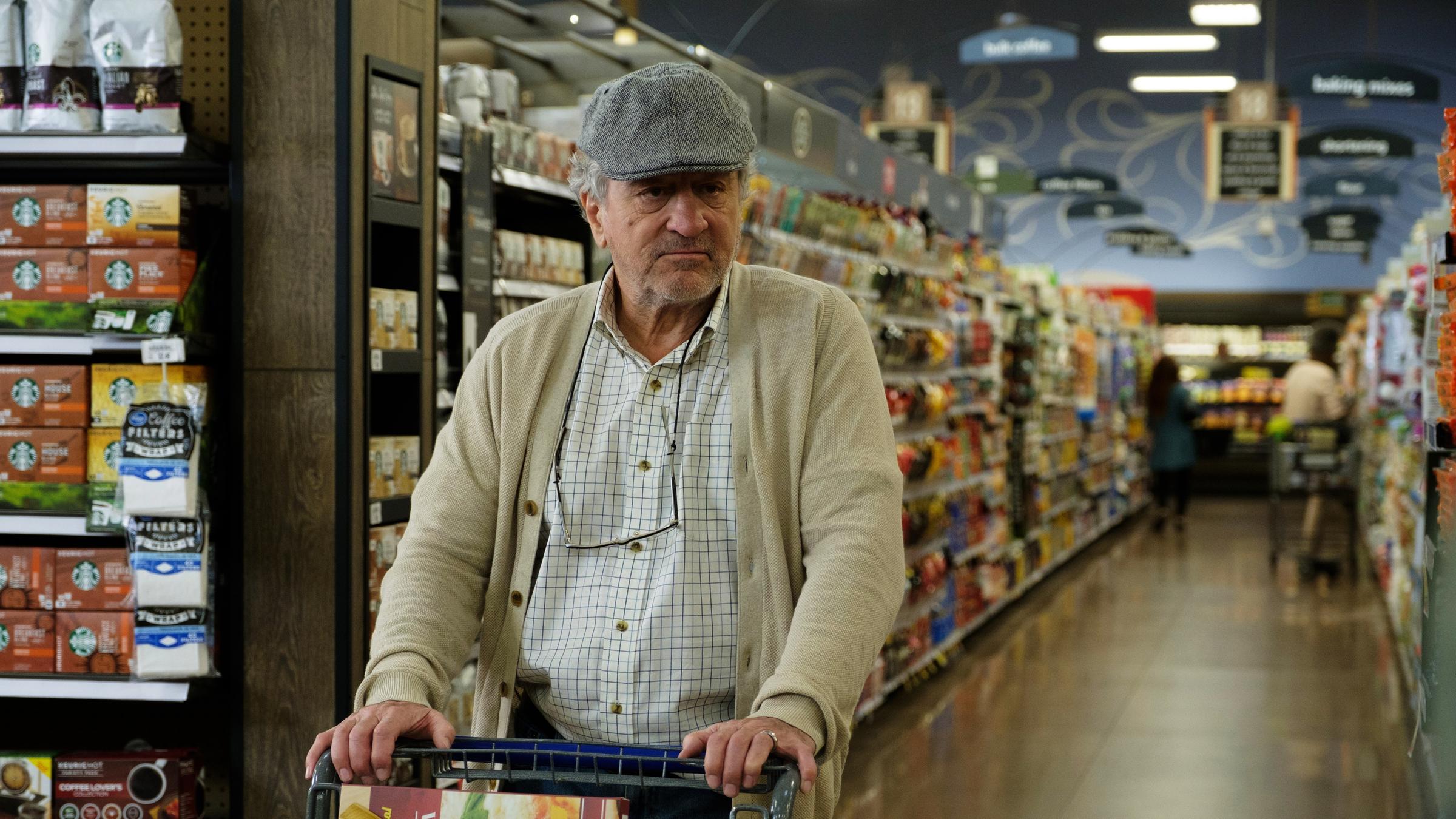 "Immer Ärger mit Grandpa": Ein mürrisch blickender älterer Herr, Ed (Robert De Niro), in Strickjacke und Baseball-Cap, schiebt in einem Supermarkt einen befüllten Einkaufswagen vor sich her.