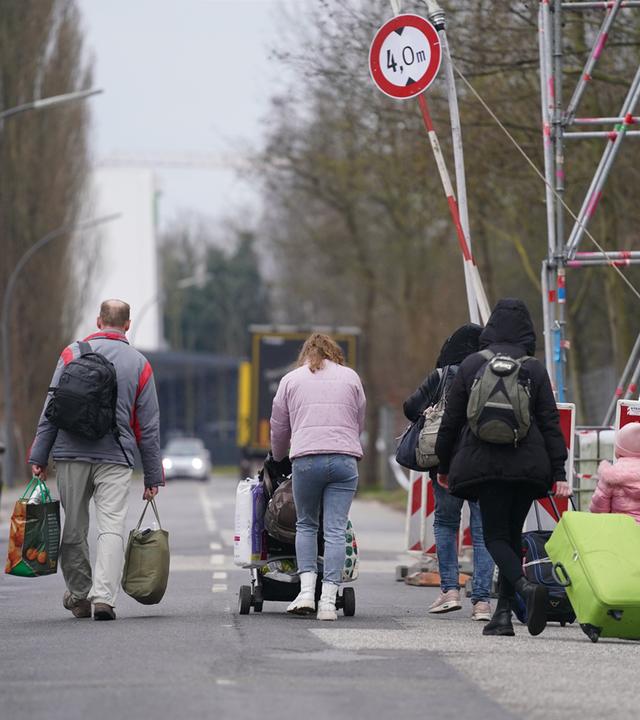 Mehrere Menschen laufen auf der Straße, an der Seite sind Absperrungen zu sehen.