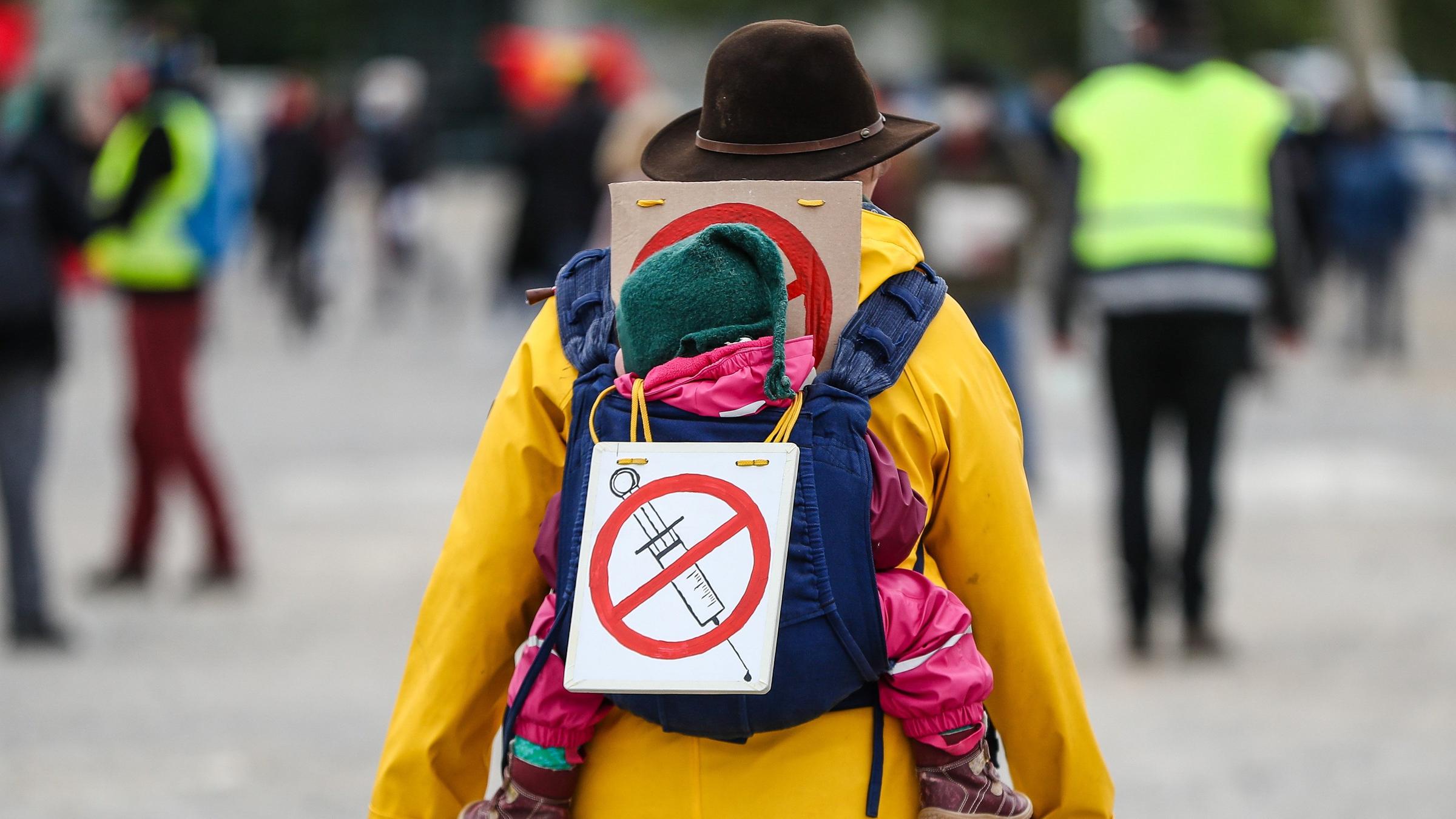 Teilnehmerin einer Protestkundgebung der Initiative «Querdenken» trägt ein Schild gegen Impfungen auf ihrem Rücken