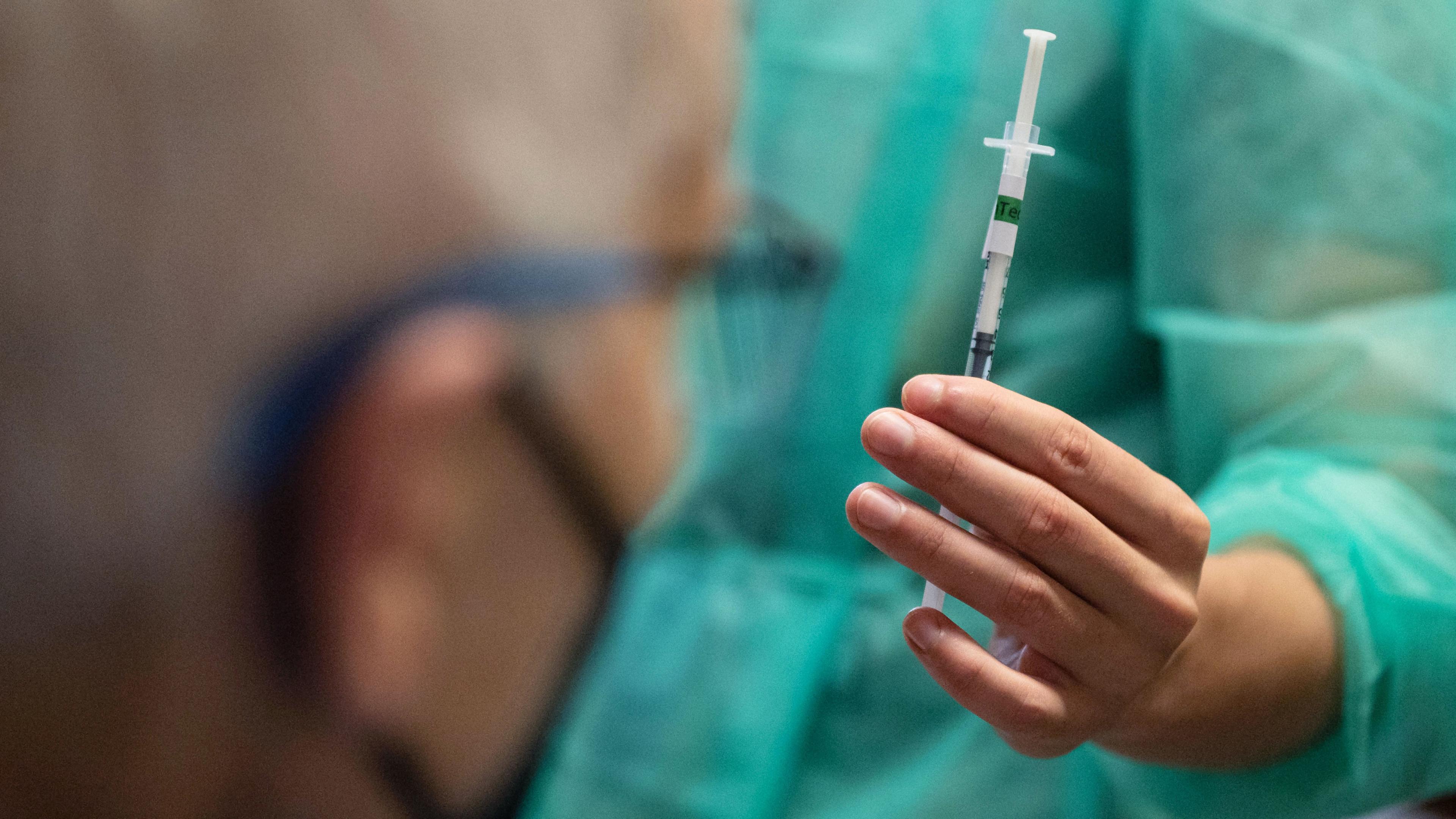 Eine Mitarbeiterin des Mobilen Impfteams Tübingen zeigt einem Impfling seine Impfung mit dem Wirkstoff von Biontech