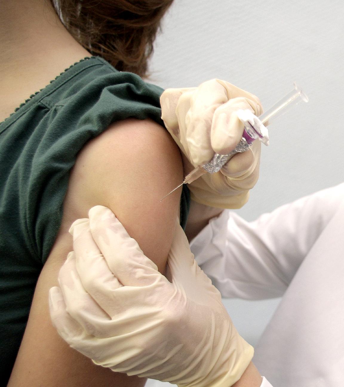 Ärztin impft ein junges Mädchen