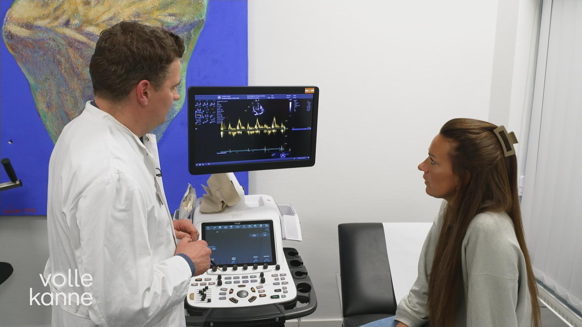 Patientin und Arzt stehen vor einem EKG