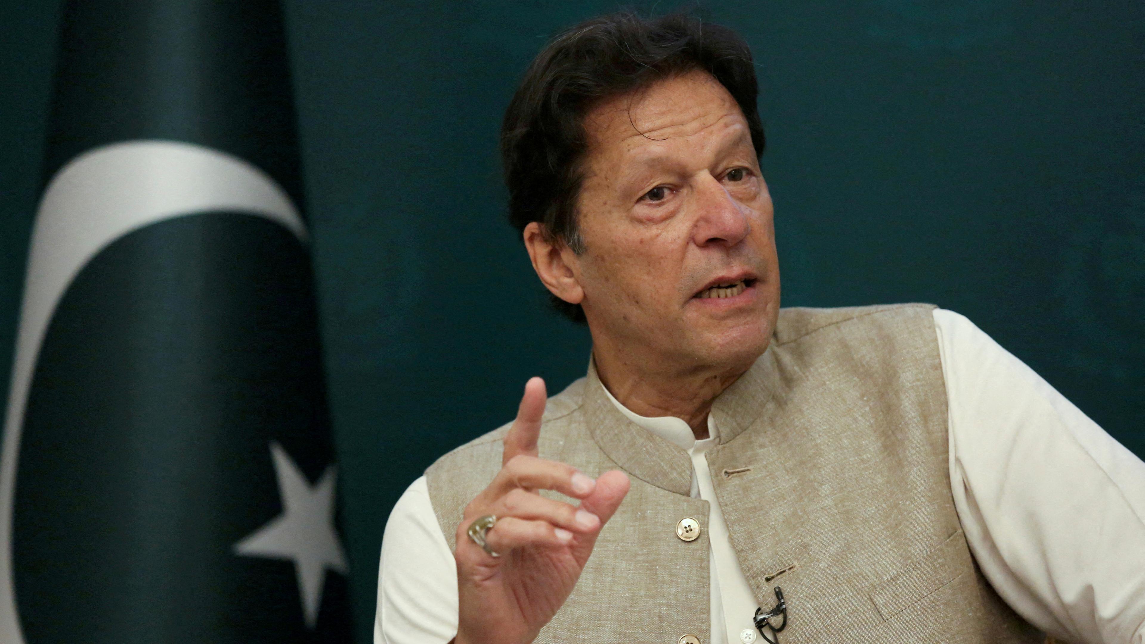 Der Premierminister von Pakistan Imran Khan vor grünem Hintergrund. Links hinter ihm die pakistanische Flagge.