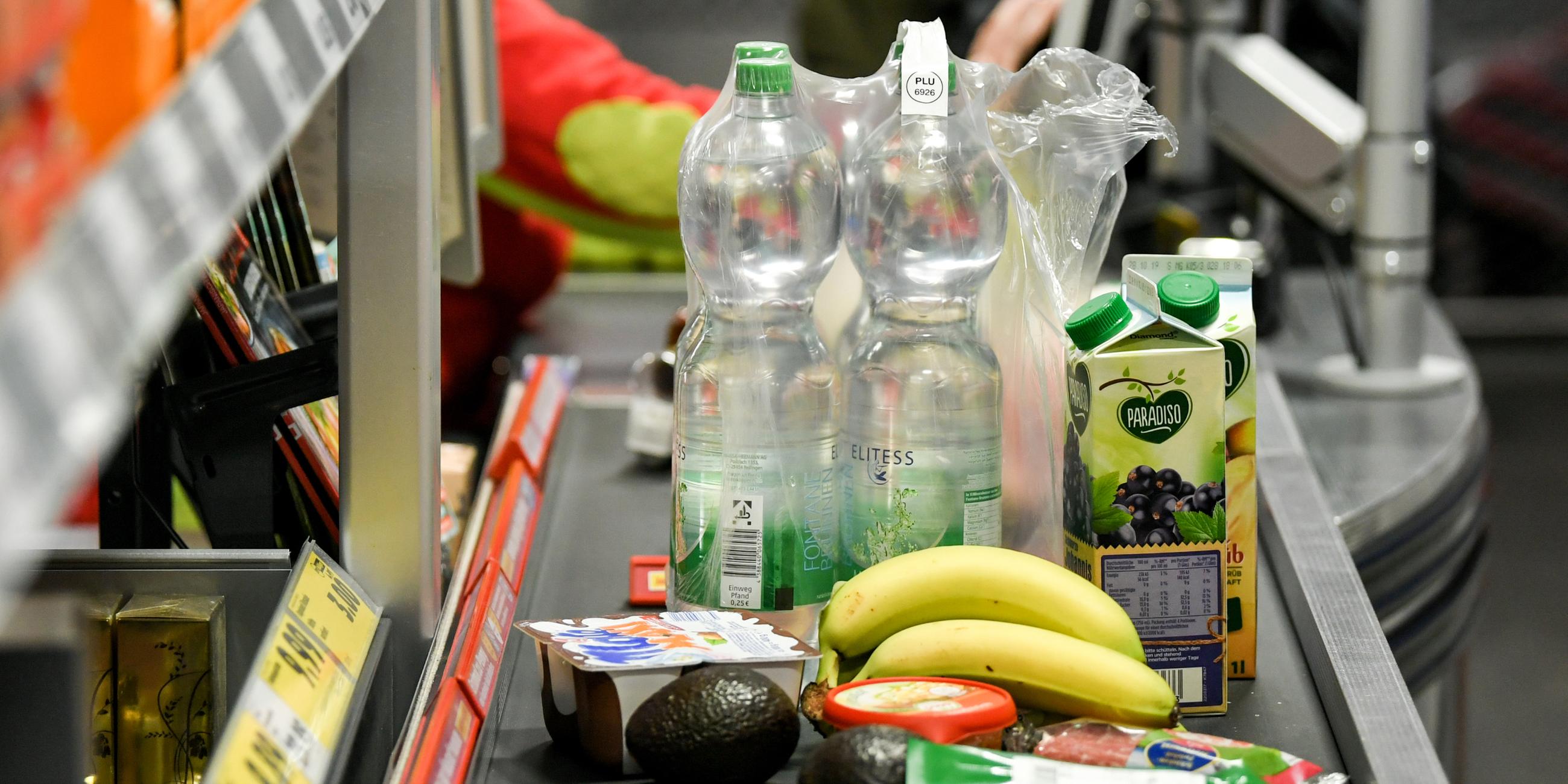 Verschiedene Lebensmittel stehen auf dem Band einer Supermarktkasse