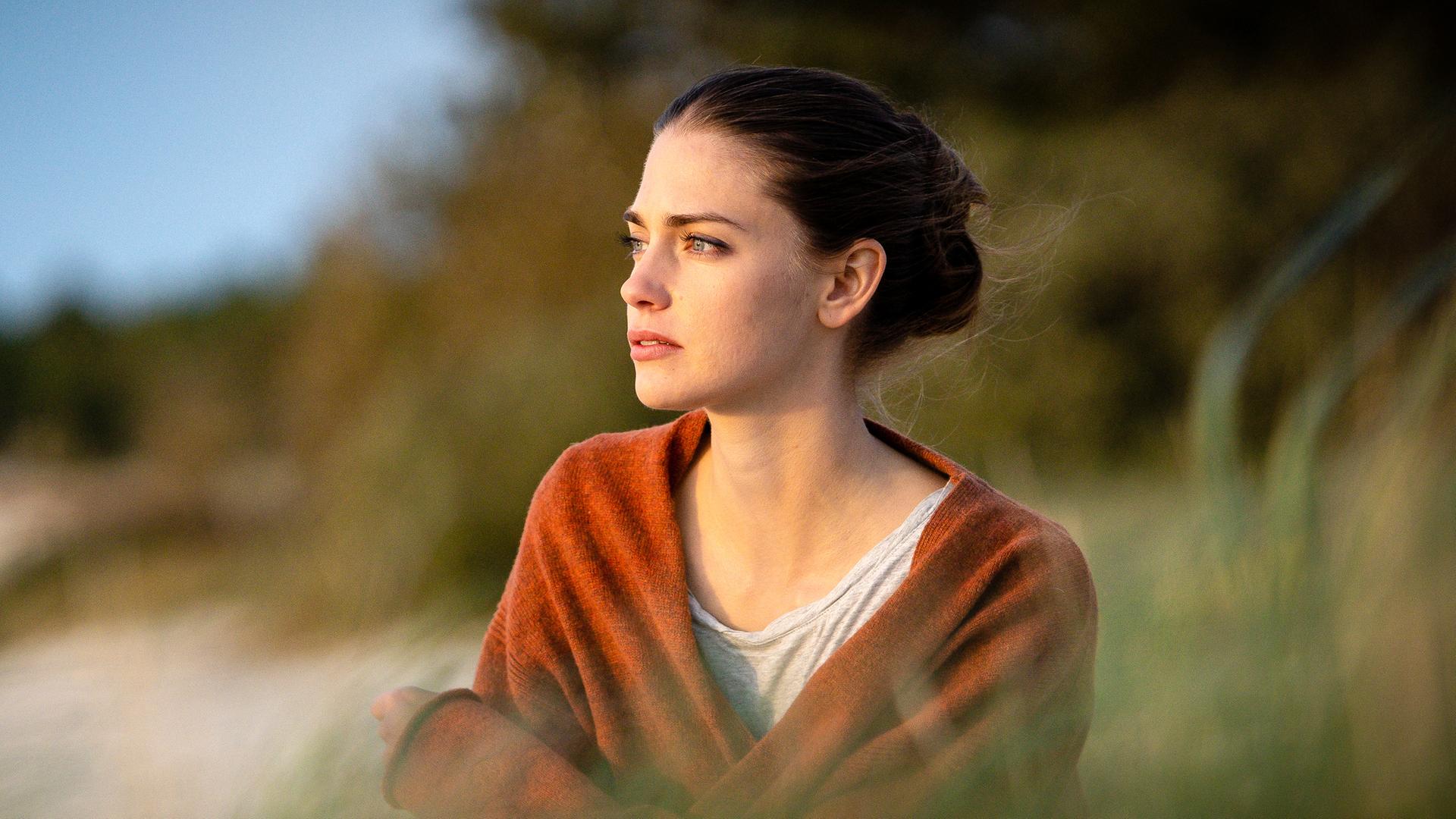 Astrid (Laura Berlin) in den Dünen, sie schaut sehr nachdenklich aufs Meer