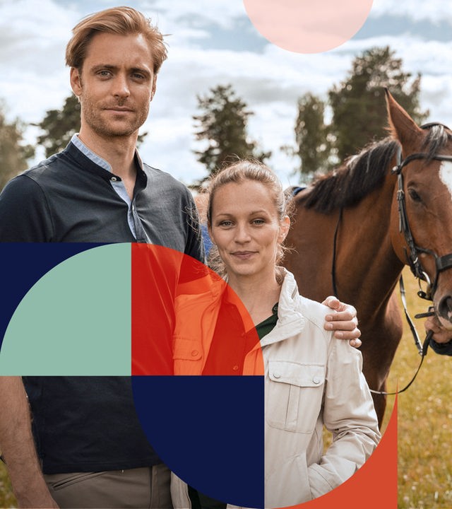 "Inga Lindström: Das Haus am See": Birger umarmt Liv. Mikael hält mit seiner rechten Hand ein Pferd am Zügel, und Ingmars rechte Hand liegt auf Mikaels linker Schulter. Alle stehen mit Blick nach vorne auf einer grünen Wiese.