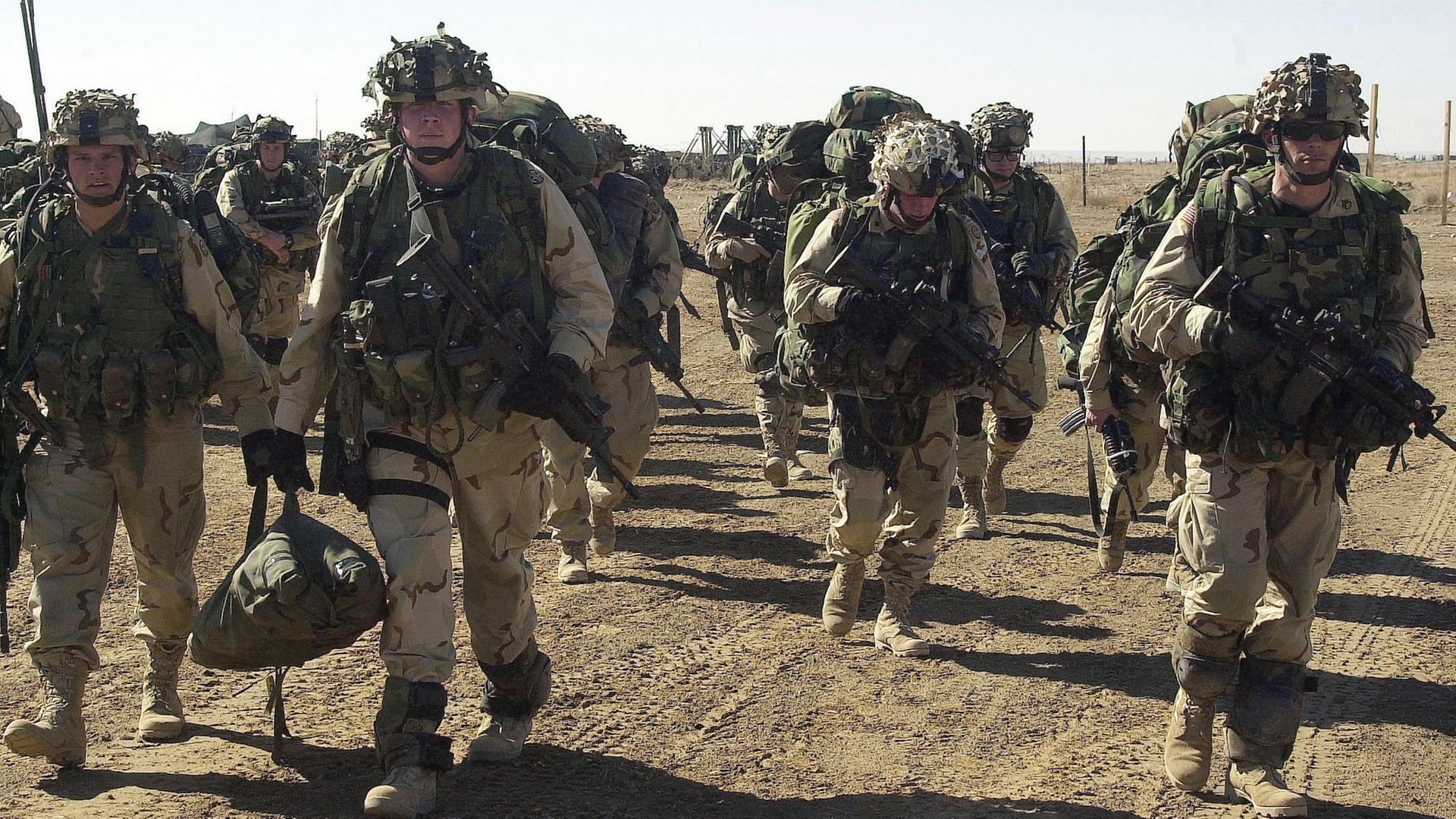 "Inside NATO: Krieg und neue Feinde": US-Soldaten marschieren in voller Kampfausstattung durch die Wüste Afghanistans.