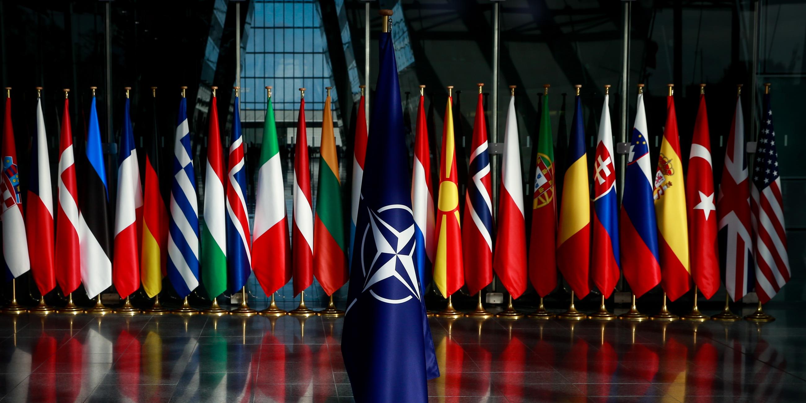 NATO-Flagge, die vor den Flaggen der Mitgliedsstaaten des Bündnisses platziert ist.