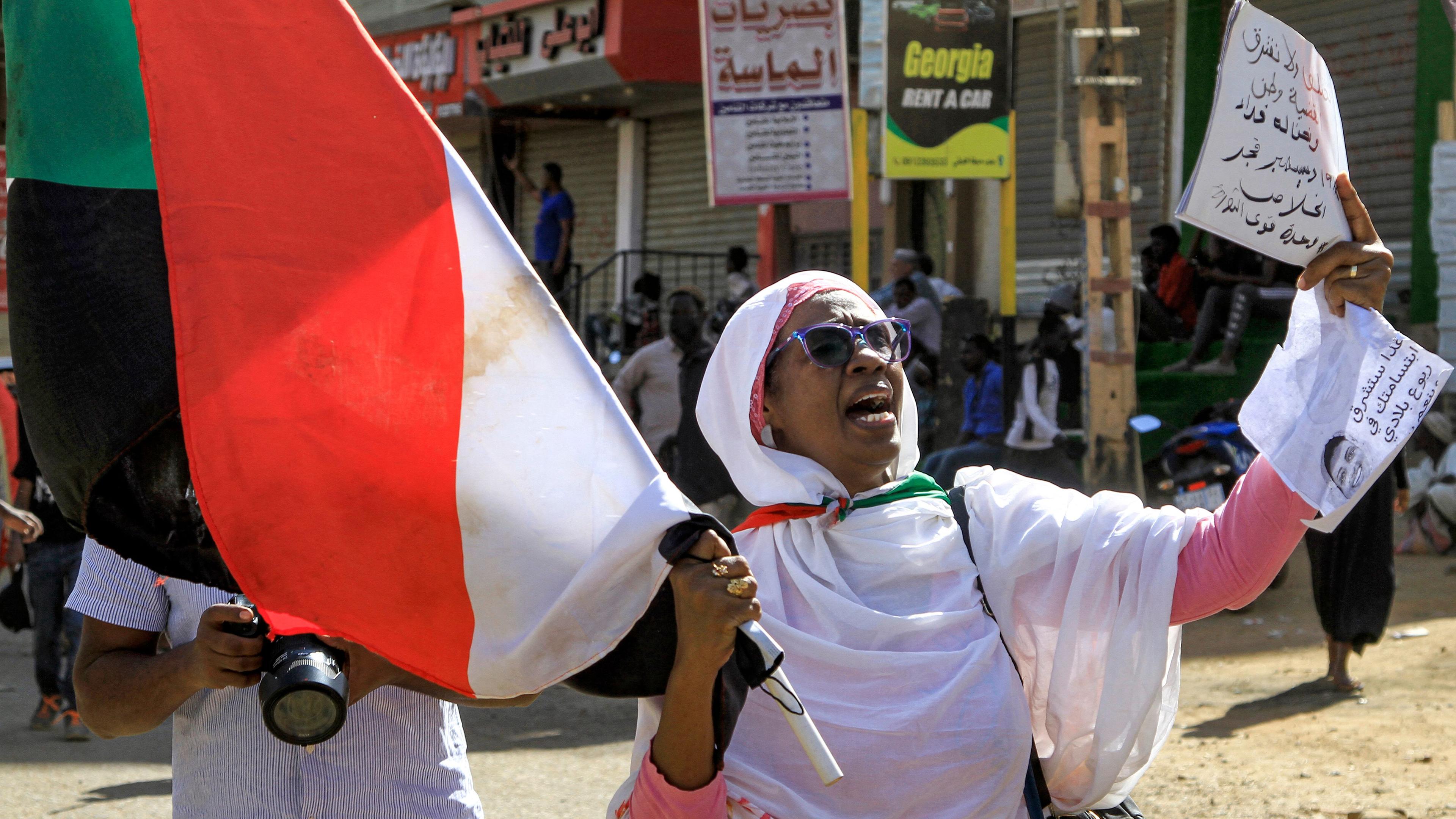 Sudanesin protestiert mit Nationalflagge