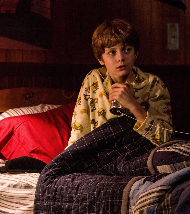 "Insidious: Chapter 2": Dalton (Ty Simpkins) sitzt ängstlich in seinem Bett und umklammert sein selbst gebasteltes Dosentelefon.
