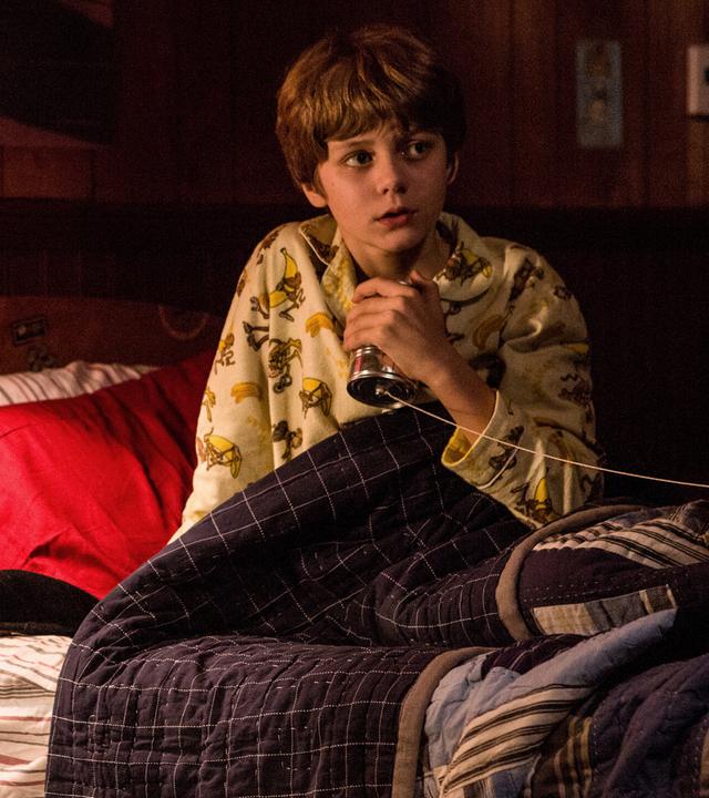 "Insidious: Chapter 2": Dalton (Ty Simpkins) sitzt ängstlich in seinem Bett und umklammert sein selbst gebasteltes Dosentelefon.