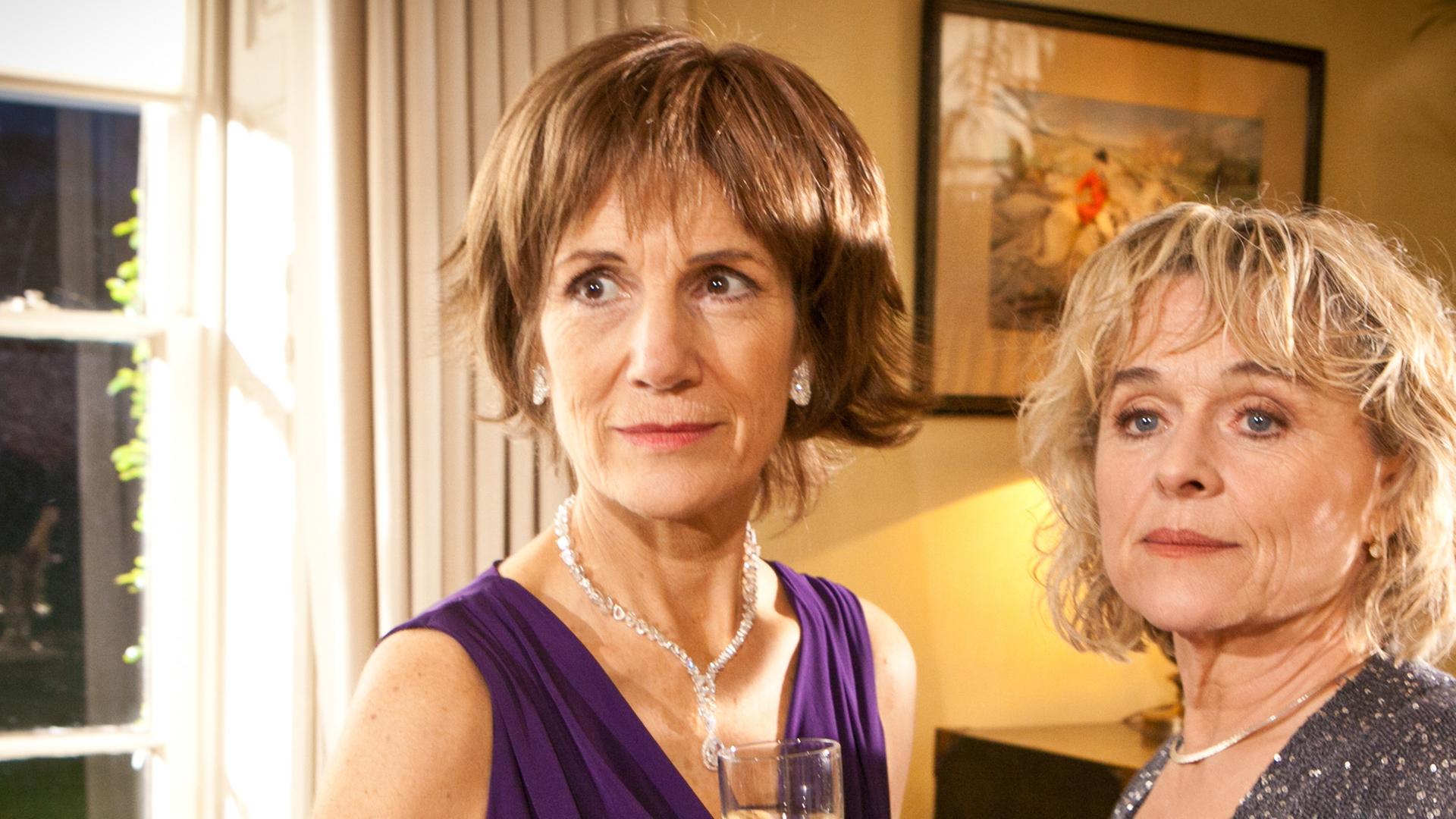 Die Schwestern Diana Davenport (Harriet Walter) und Stella Harris (Sinéad Cusack) stehen nebeneinander in einem Zimmer