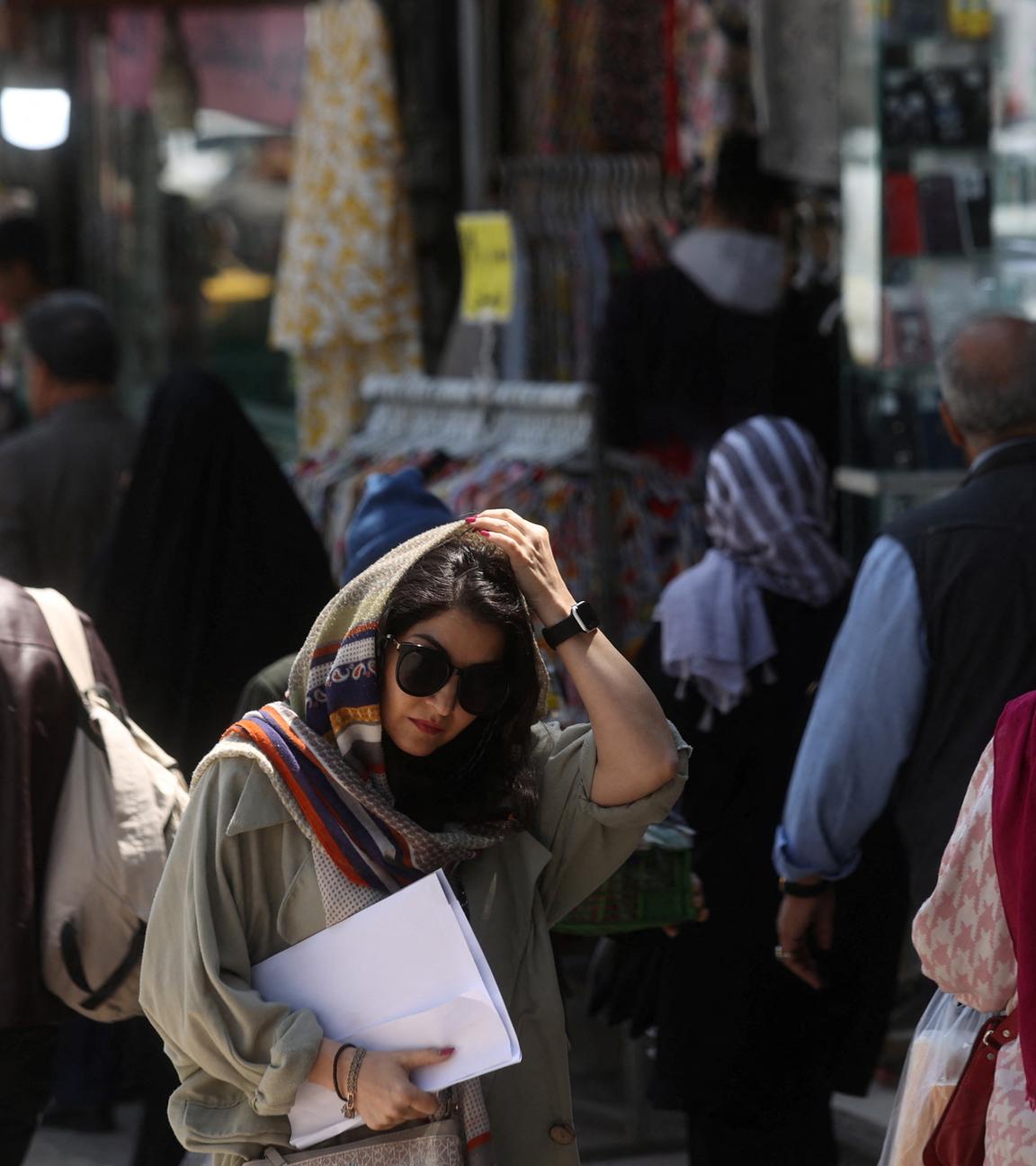 Frauen mit Kopftüchern laufen auf einer Straße in Teheran