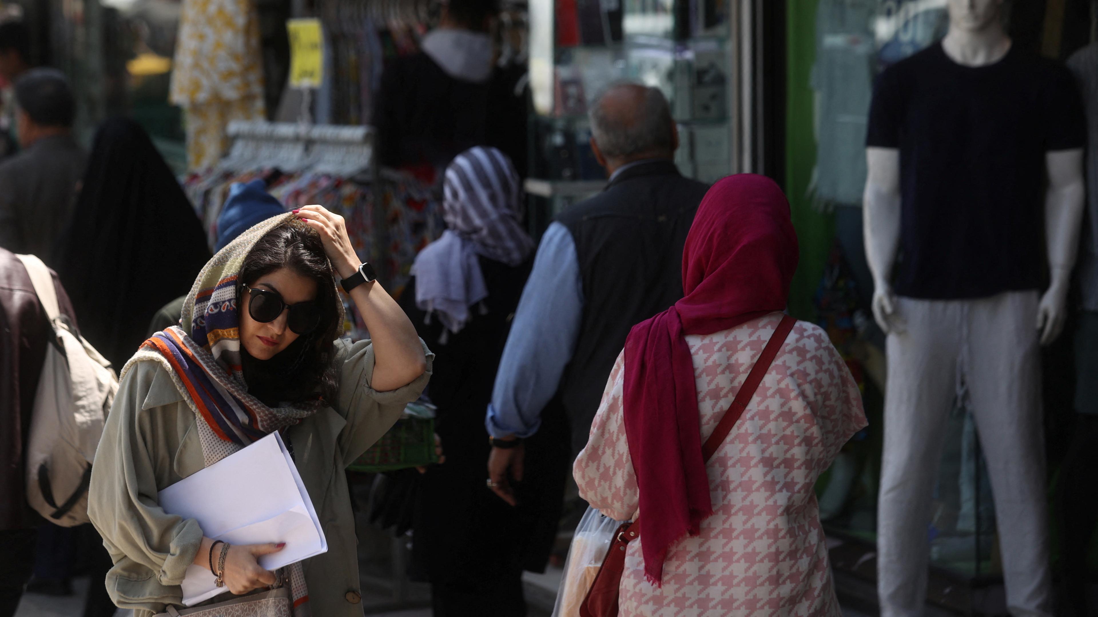 Frauen mit Kopftüchern laufen auf einer Straße in Teheran