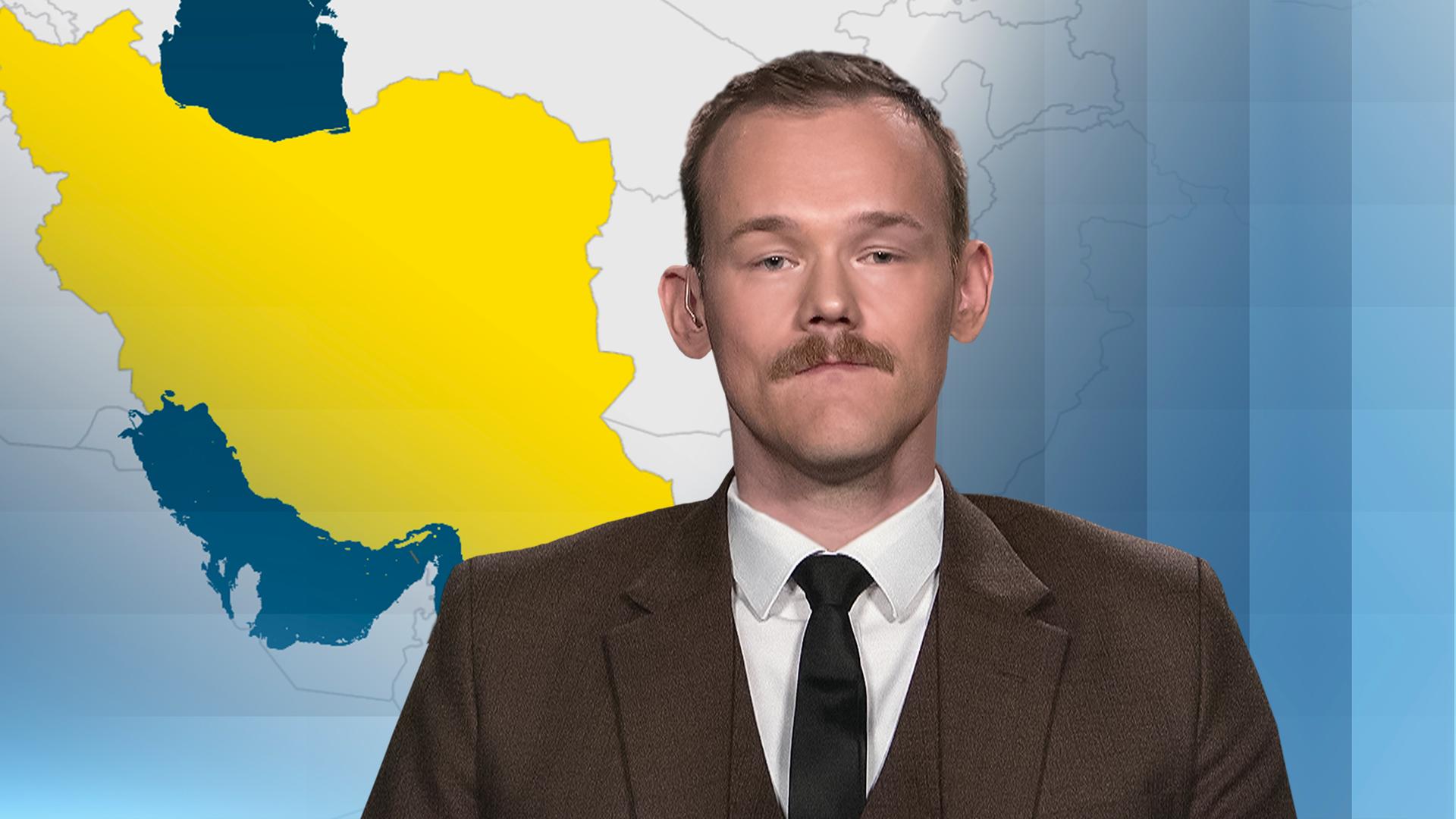 Fabian Hinz vor einer Karte des Iran. 