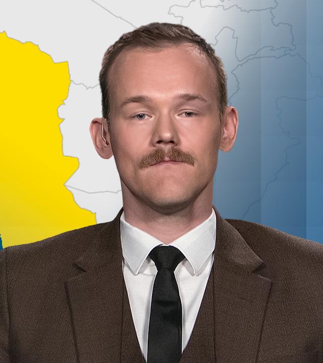 Fabian Hinz vor einer Karte des Iran. 