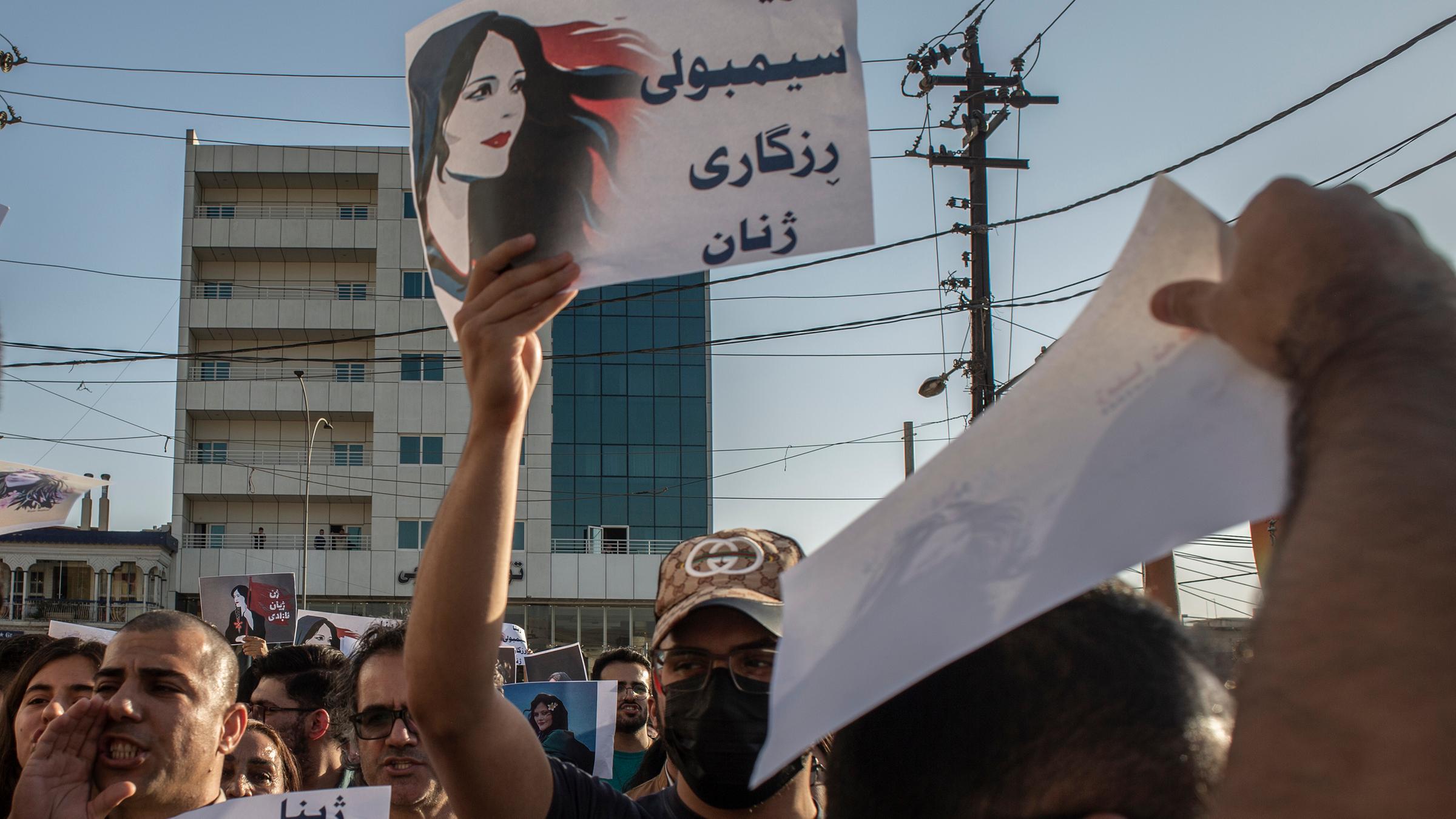 Menschen protestieren und halten Schilder um den Tod von Mahsa Amini zu verurteilen