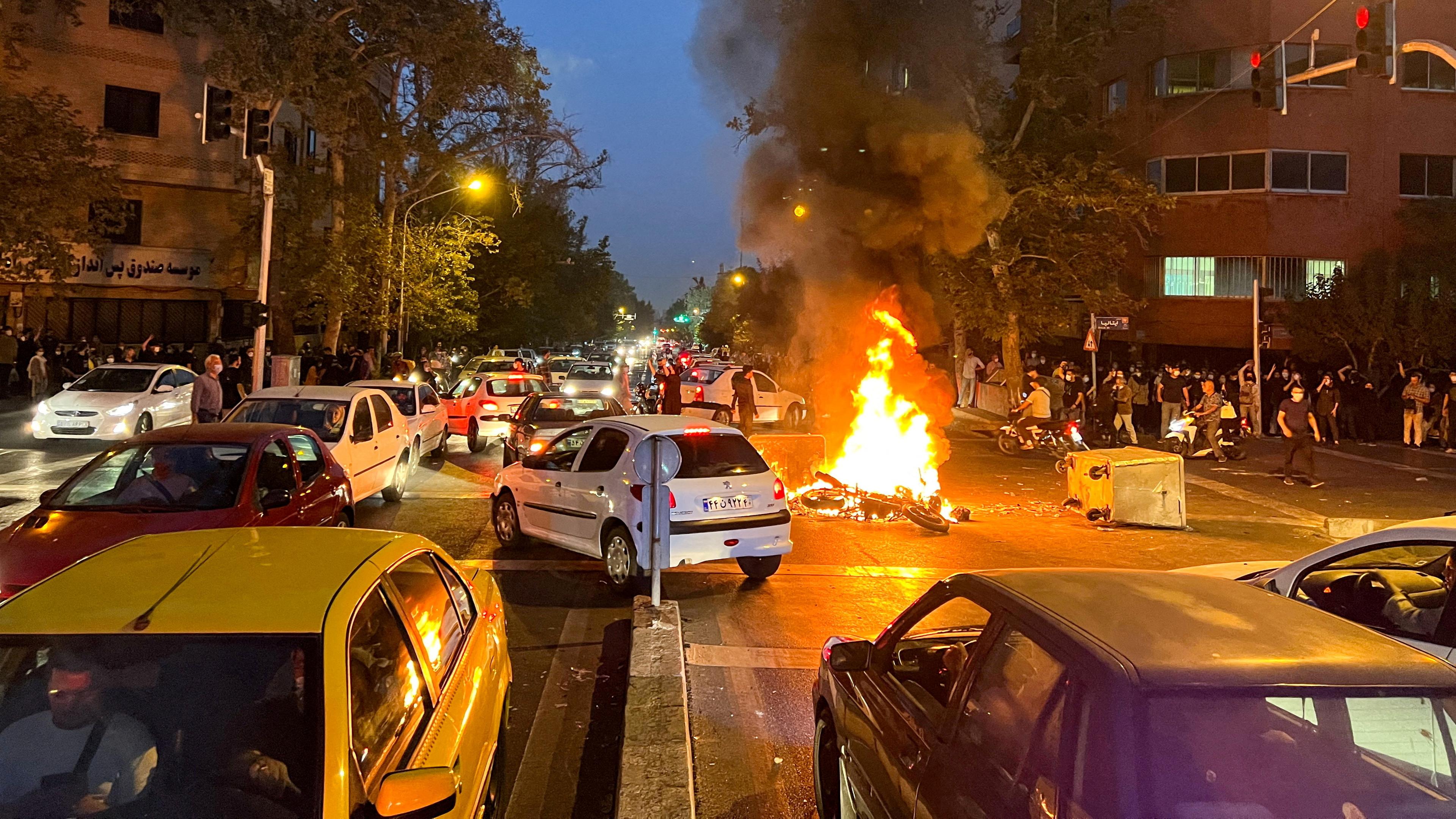 Auf einer Straßenkreuzung in Teheran steht ein Motorrad der Polizei in Flammen; Teheran, Iran; 11.11.2022