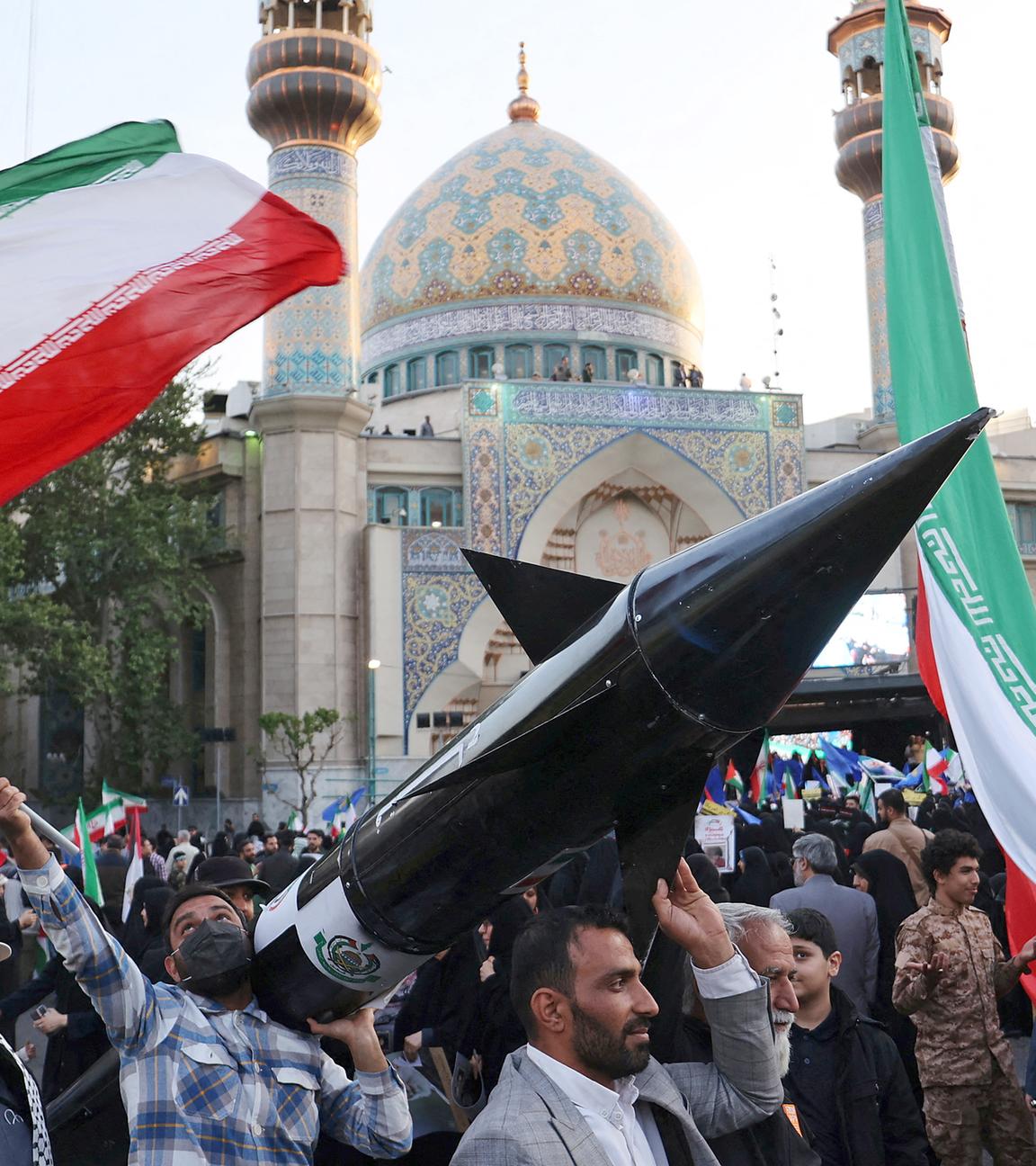 Iraner tragen ein Modell einer Rakete während einer Feier nach dem Angriff der IRGC auf Israel in Teheran (Iran), aufgenommen am 15.04.2024