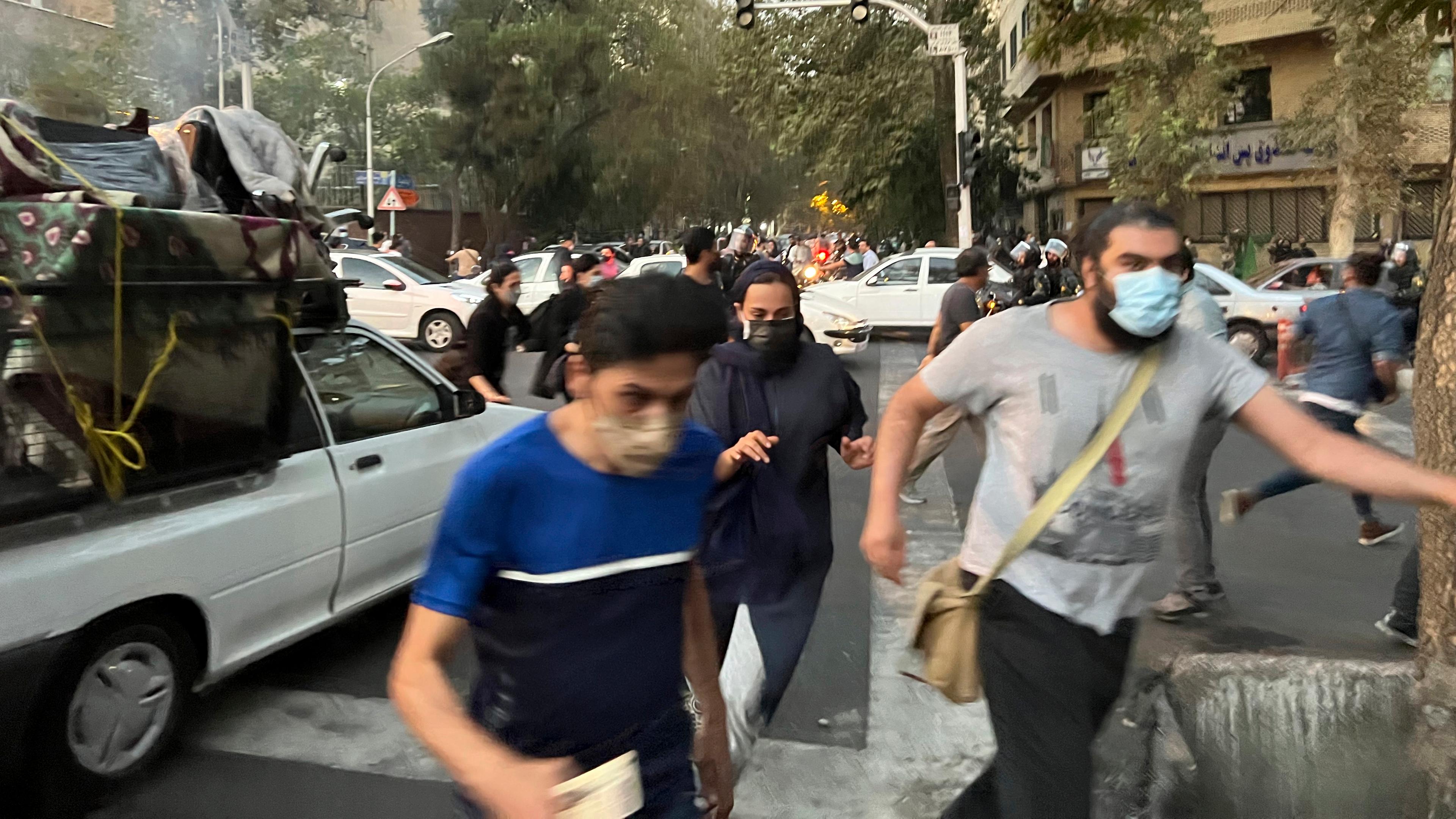 Iran, Teheran: Menschen fliehen vor der Polizei während eines Protestes gegen den Tod einer jungen Frau, die festgenommen wurde, weil sie gegen die konservative Kleiderordnung des Landes verstoßen hatte.