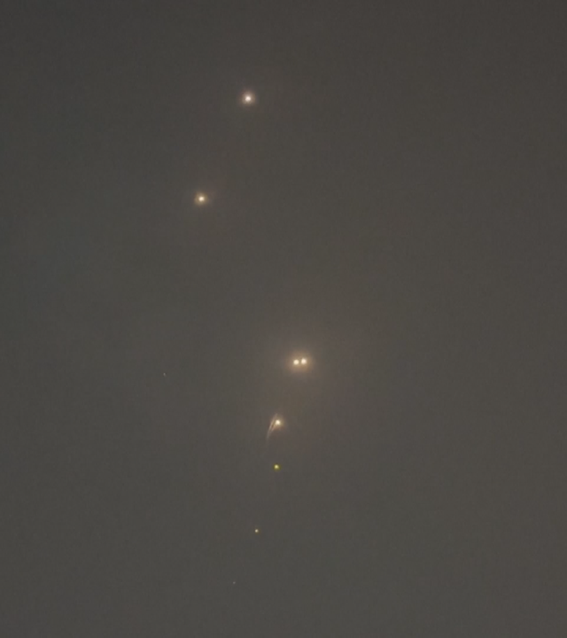 Nachthimmel über Doha, in dem leuchtende Punkte zu sehen sind.