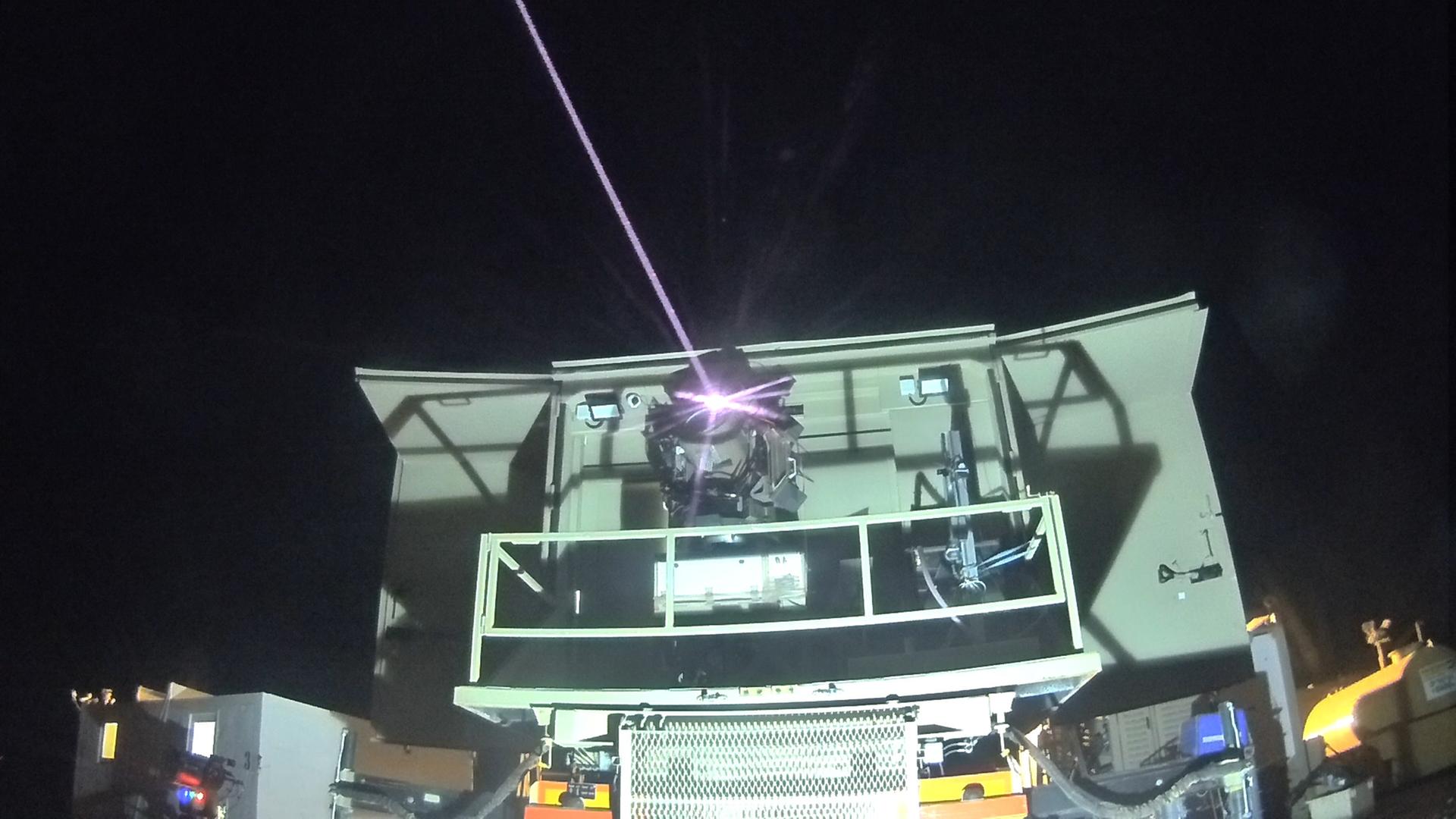 Das Bild zeigt das israelische Raketenabwehrsystem Iron Beam, das seinen Laserstrahl in den schwarzen Nachthimmel schießt.